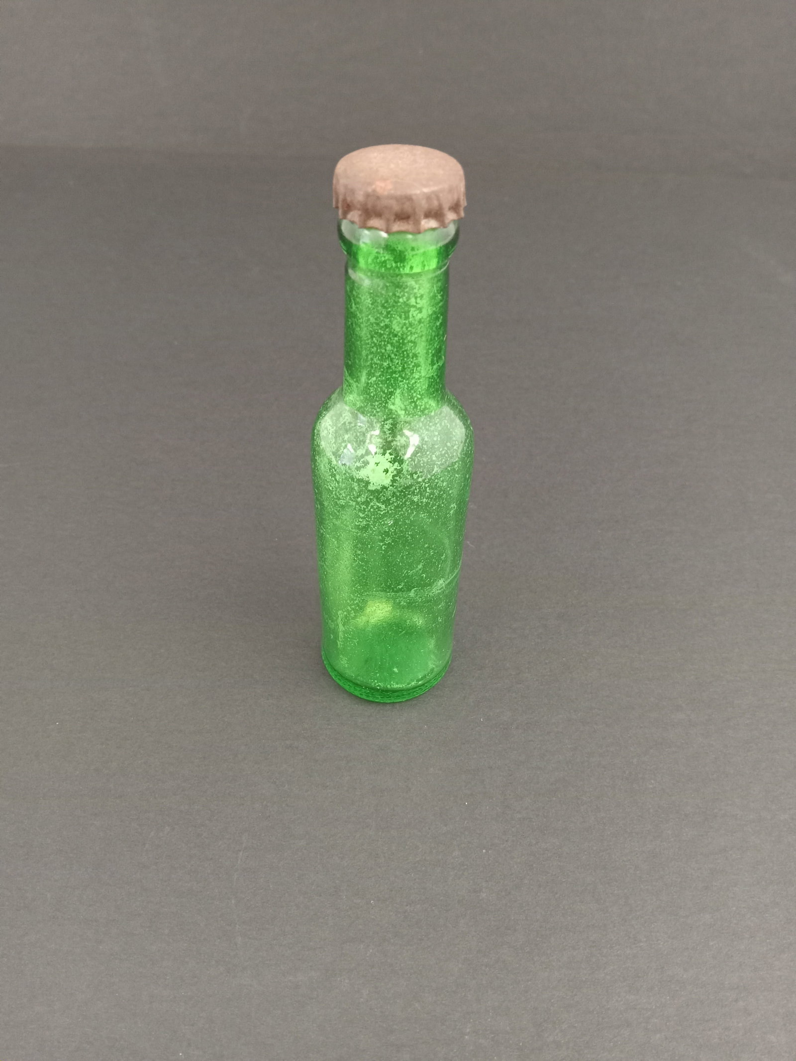 Vintage Green Glass Bottle: vintage green depression glass miniature oil or vinegar bottle with a metal cap. Measures about 4 inches tall These are part of the estate sale and we do not have a COA. All lots offered in our auctio