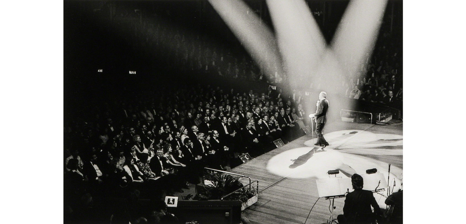 Terry O'Neill Frank Sinatra Serenades his Ex-Wife Ava Gardner at the Royal Albert Hall, London: Terry O'Neill Frank Sinatra Serenades his Ex-Wife Ava Gardner at the Royal Albert Hall, London, 1975 printed later. Photo print on Kodak photo-paper. Measures 15-1/5x 23-1/10 inches. These are part