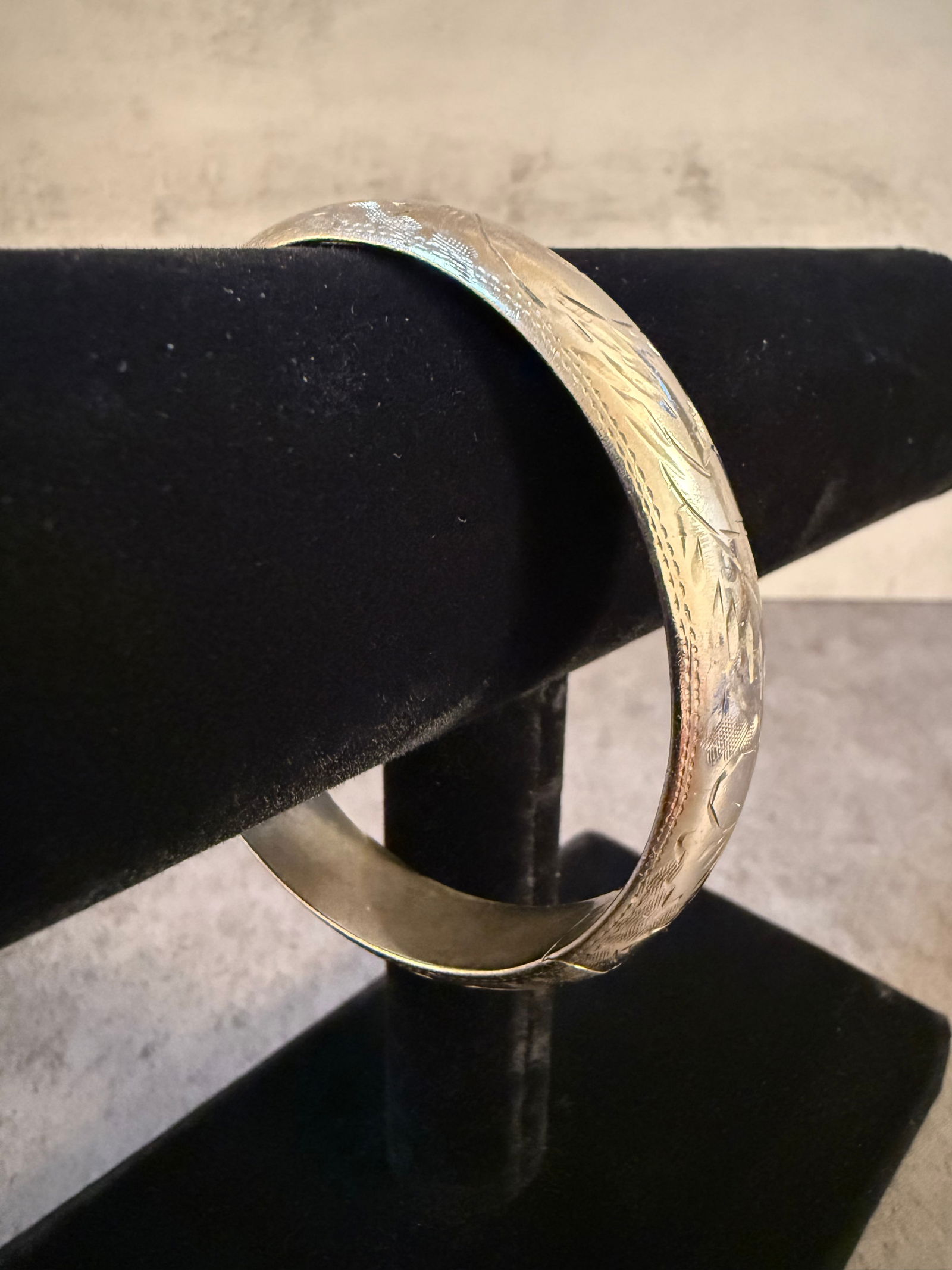 Sterling Silver Bangle Bracelet, Hinged: Sterling silver bangle bracelet of hinged construction. The exterior is finely engraved with an allover foliate and geometric motif. Crafted in solid sterling silver (.925), finished with a concealed