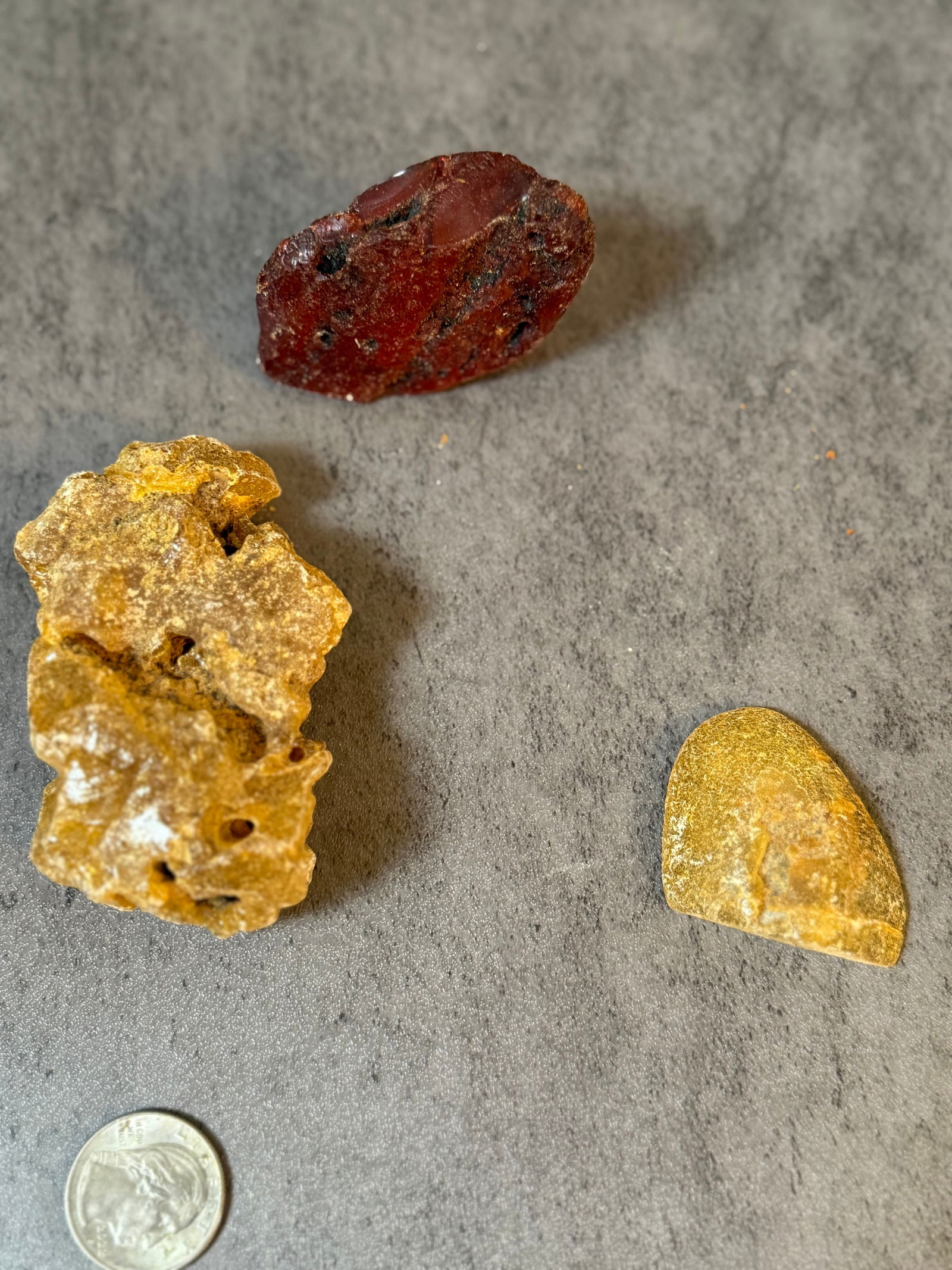 Group of Three amber Chunks: A mixed vintage material lot consisting of several amber resin chunks or cut sections, along with miscellaneous small components.The materials appear to be early resin or similar synthetic material,