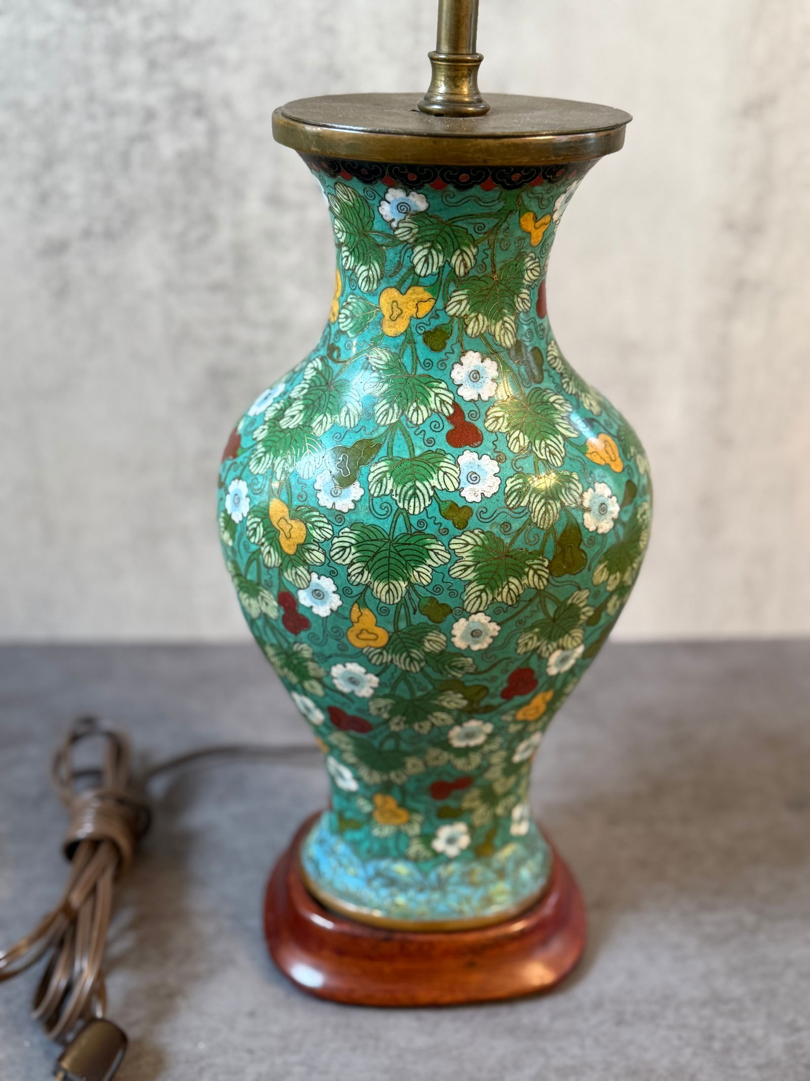 Chinese Cloisonné Bronze Bottle-Form Table Lamp with Floral Decoration: A Chinese cloisonné bronze bottle-form table lamp, decorated with dense scrolling floral motifs on a turquoise ground. The waisted body displays finely detailed enamel work throughout, creating a ric