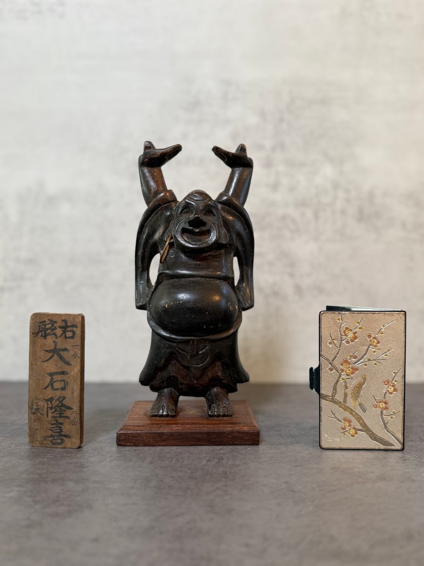 Group of Three Japanese Articles Including Carved Wood Figure, Inscribed Wood Tablet and Metal Card: A group of three Japanese articles comprising: a carved wood figure of Hotei depicted with arms raised and protruding belly, mounted on a hardwood base; an inscribed rectangular wood tablet with