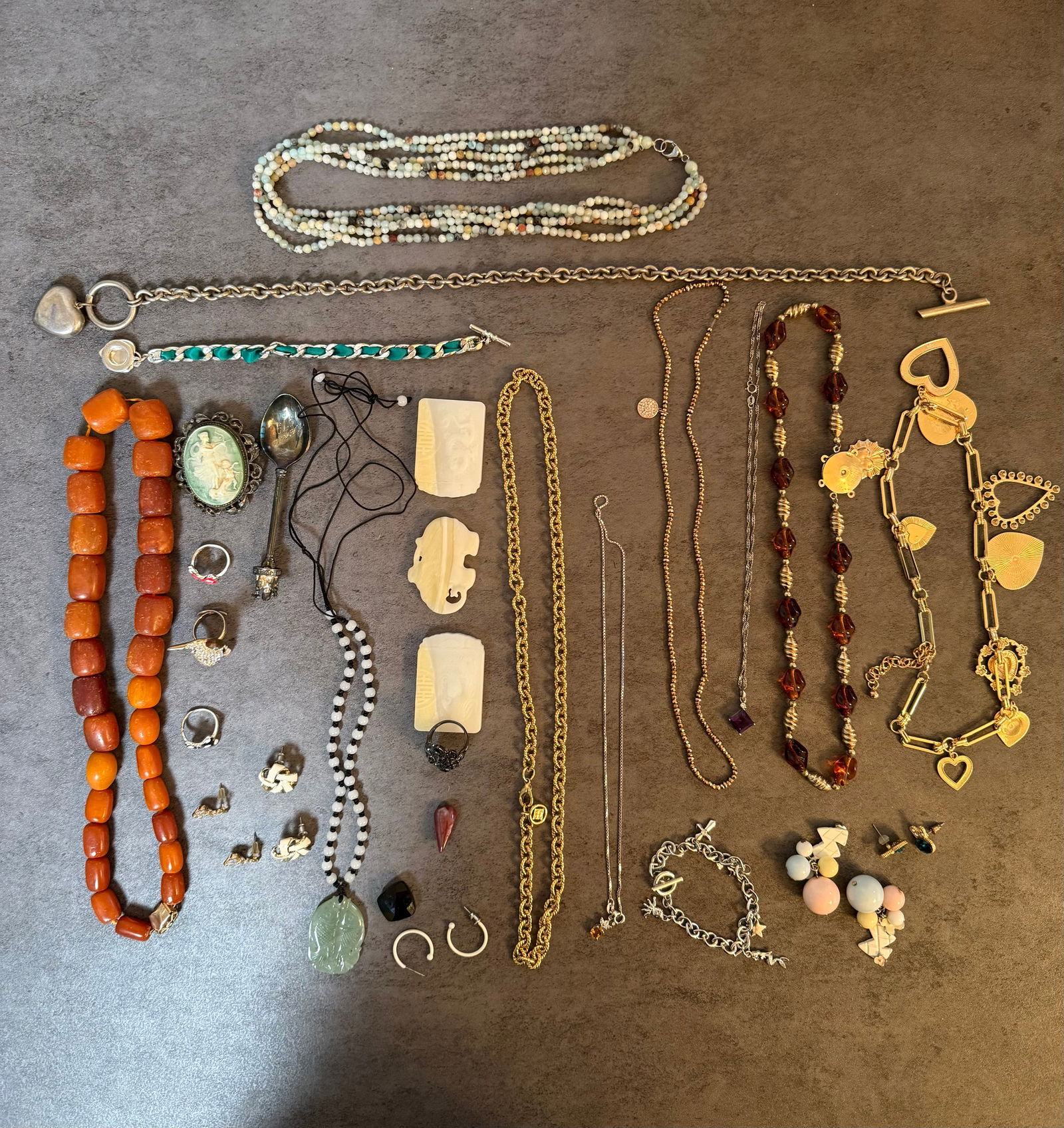 Large Group of Costume and Vintage Jewelry Including Beaded Necklaces, Bracelets, Earrings and More: A large group of costume and vintage jewelry comprising: a chunky amber-colored bead necklace; a multi-strand beaded necklace; a cameo brooch; carved jade pendant; carved bone or ivory-colored