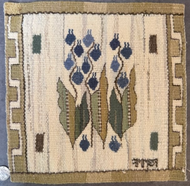 Signed Vintage Hand Embroidered Needlepoint Floral Textile Panel: A vintage hand-embroidered needlepoint textile panel featuring a stylized floral motif with blue blossoms and green leaves within a geometric border. The design is worked in wool thread on canvas.The