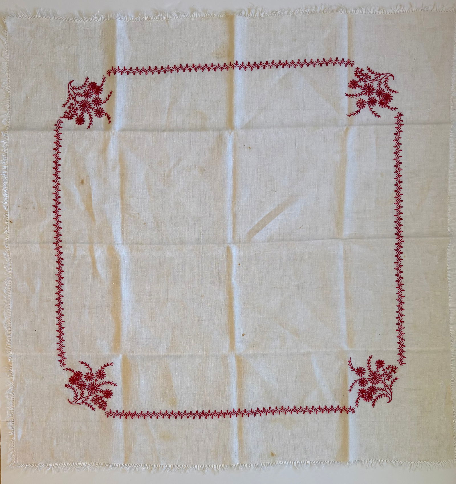 Vintage Hand Embroidered Linen Tablecloth with Red Floral Border, 35 x 35 in: Vintage linen tablecloth featuring hand embroidered red floral corner motifs and a decorative border on natural linen. Traditional folk style embroidery typical of European household textiles from