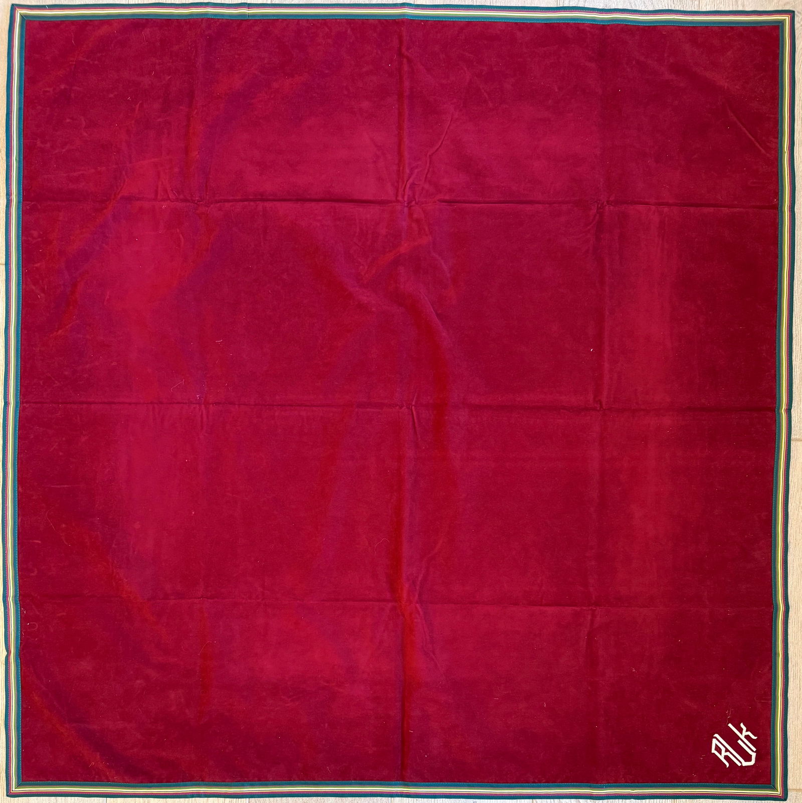 Ralph Lauren Red Cotton Tablecloth with Multicolor Border, 44 x 44 in: Red cotton tablecloth by Ralph Lauren featuring the brand’s embroidered RL monogram and multicolor striped border. Classic Ralph Lauren table linen design.Dimensions: approximately 44 × 44 inches.