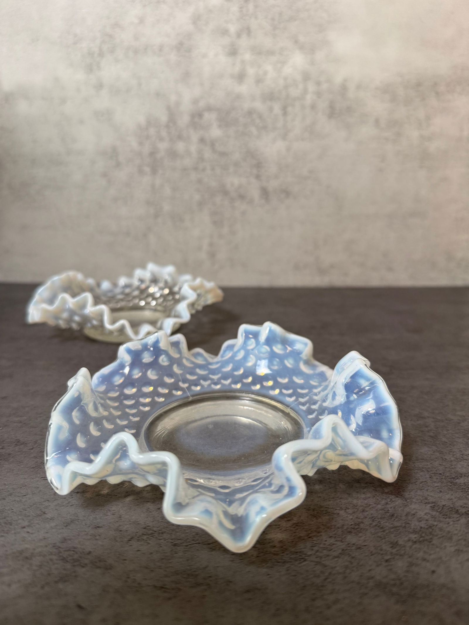 Pair of Hobnail Opalescent Glass Ruffled Bowls: Pair of decorative opalescent glass bowls featuring a hobnail pattern with ruffled edges. Translucent glass with milky opalescent tone. Each approx. 6 in diameter x 2 in H.