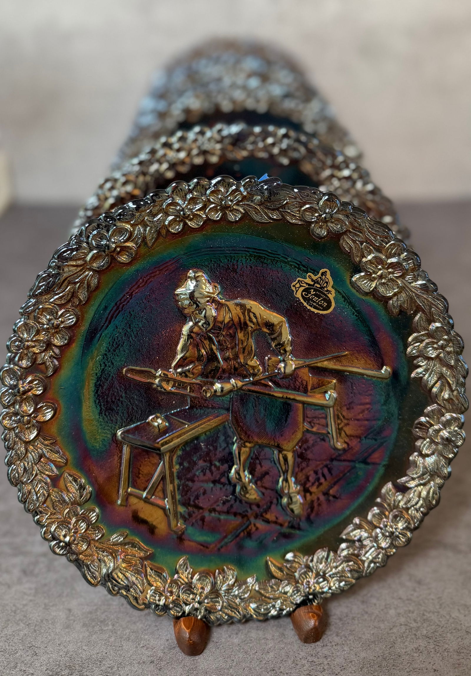 Group of 5 Fenton Carnival Glass Collector Plates: Collection of five decorative carnival glass collector plates by Fenton Art Glass. Each plate features a richly iridescent carnival finish with molded figural scenes in relief, surrounded by ornate