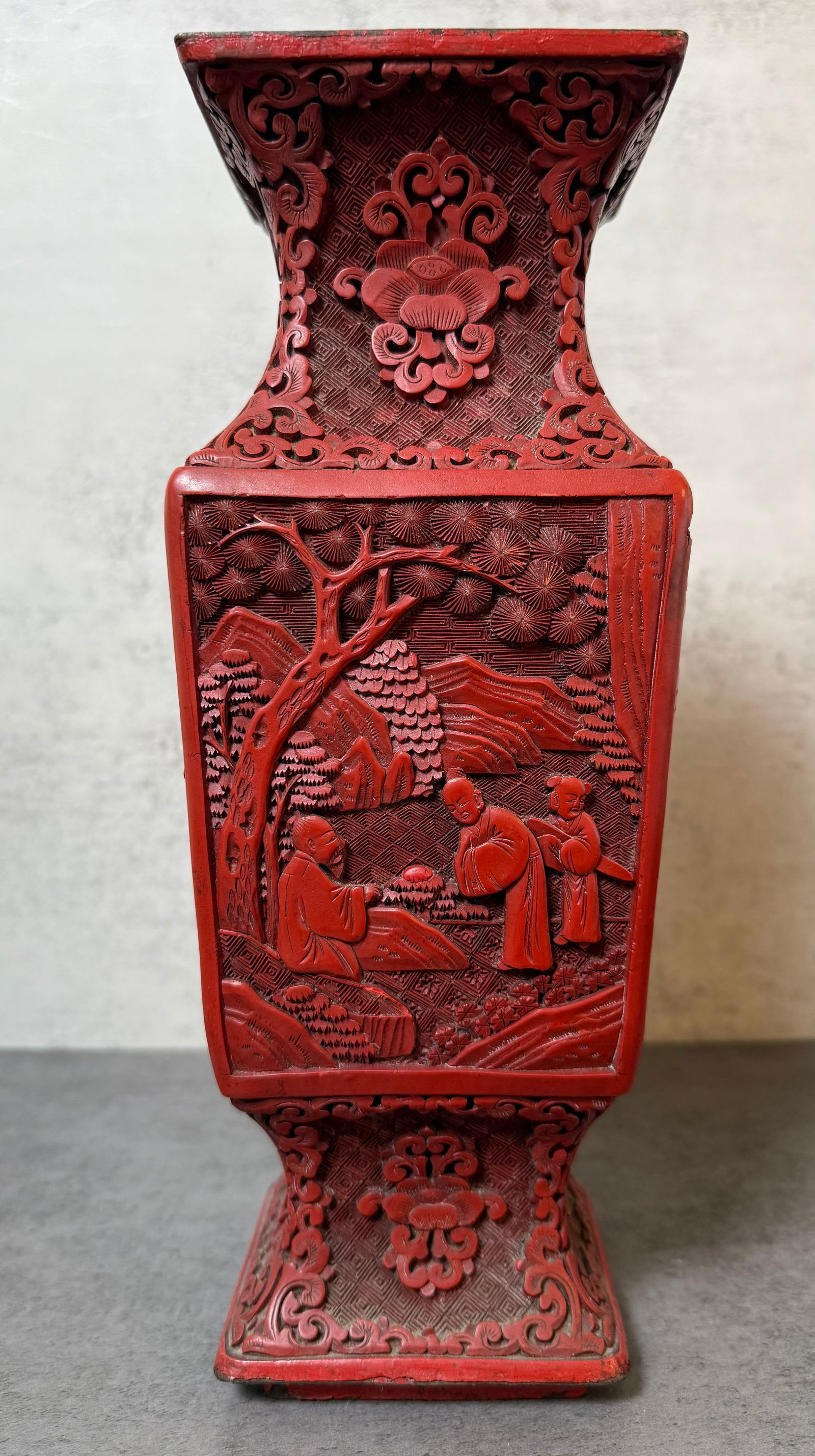 Chinese Carved Red Lacquer Vase with Figural Landscape Panels, Late Qing – Early 20th Century: Chinese carved red lacquer vase of square baluster form, each side finely carved in relief with figural landscape scenes depicting scholars in mountainous settings. The neck and foot decorated with
