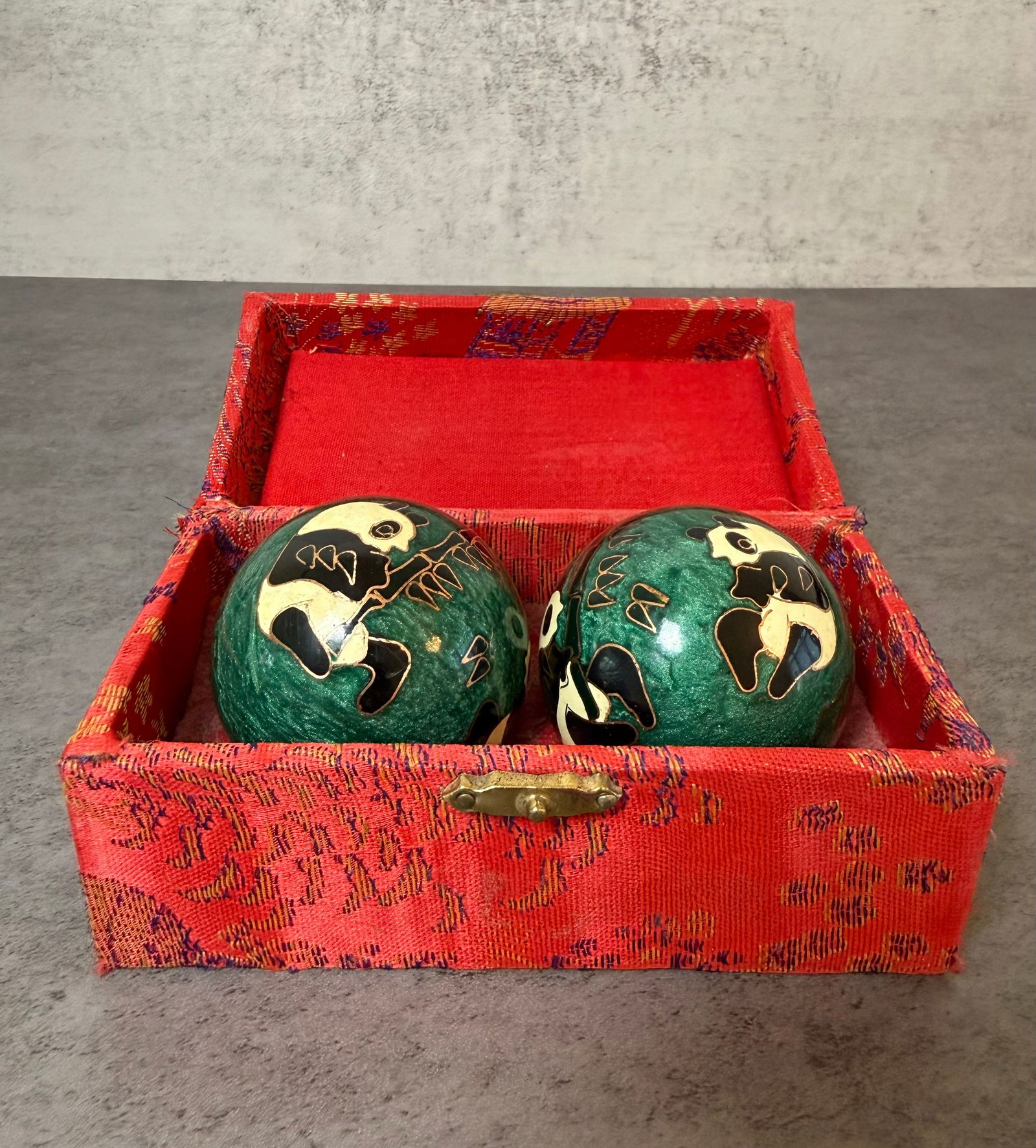 Chinese Cloisonné Panda Baoding Exercise Balls in Silk Box: A pair of Chinese cloisonné Baoding exercise balls decorated with panda motifs against a vibrant green ground. The spheres are finely ornamented with gilt wire and enamel, depicting playful pandas