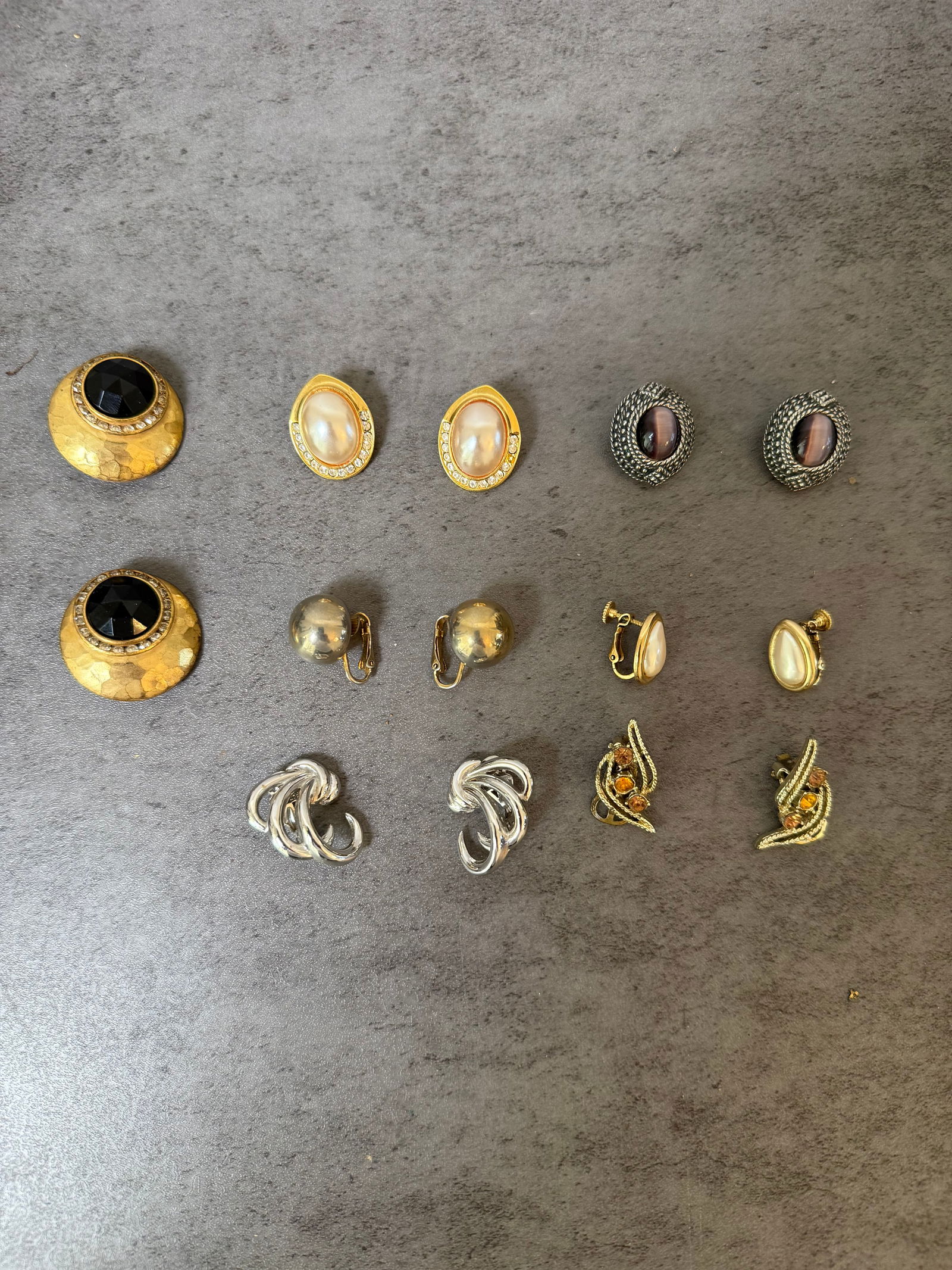 Lot of 7 Pairs Vintage Clip-On Earrings — Faux Pearl, Jet Black, Tiger's Eye, Marcasite-Style,: A polished and elegant collection of seven pairs of vintage clip-on earrings, predominantly in the glamorous style of mid-century to 1980s American costume jewelry. All pieces appear to be clip-back