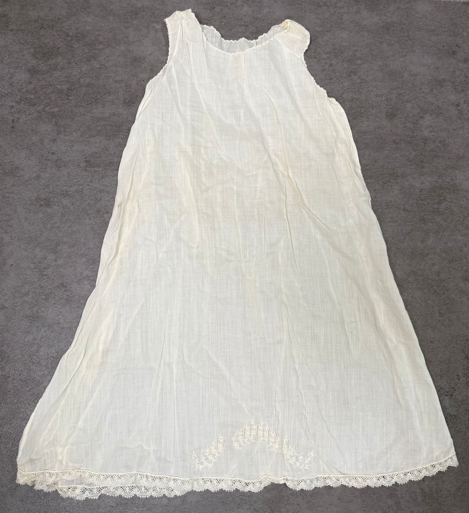 Antique White Cotton Lawn Slip Dress Lace Hem Floral Embroidery c.1900: Antique sleeveless white cotton lawn dress or slip, circa 1890–1910. Fine semi-sheer fabric with a gathered ruffle neckline, A-line silhouette, and delicate lace trim along the hem. Features hand-em