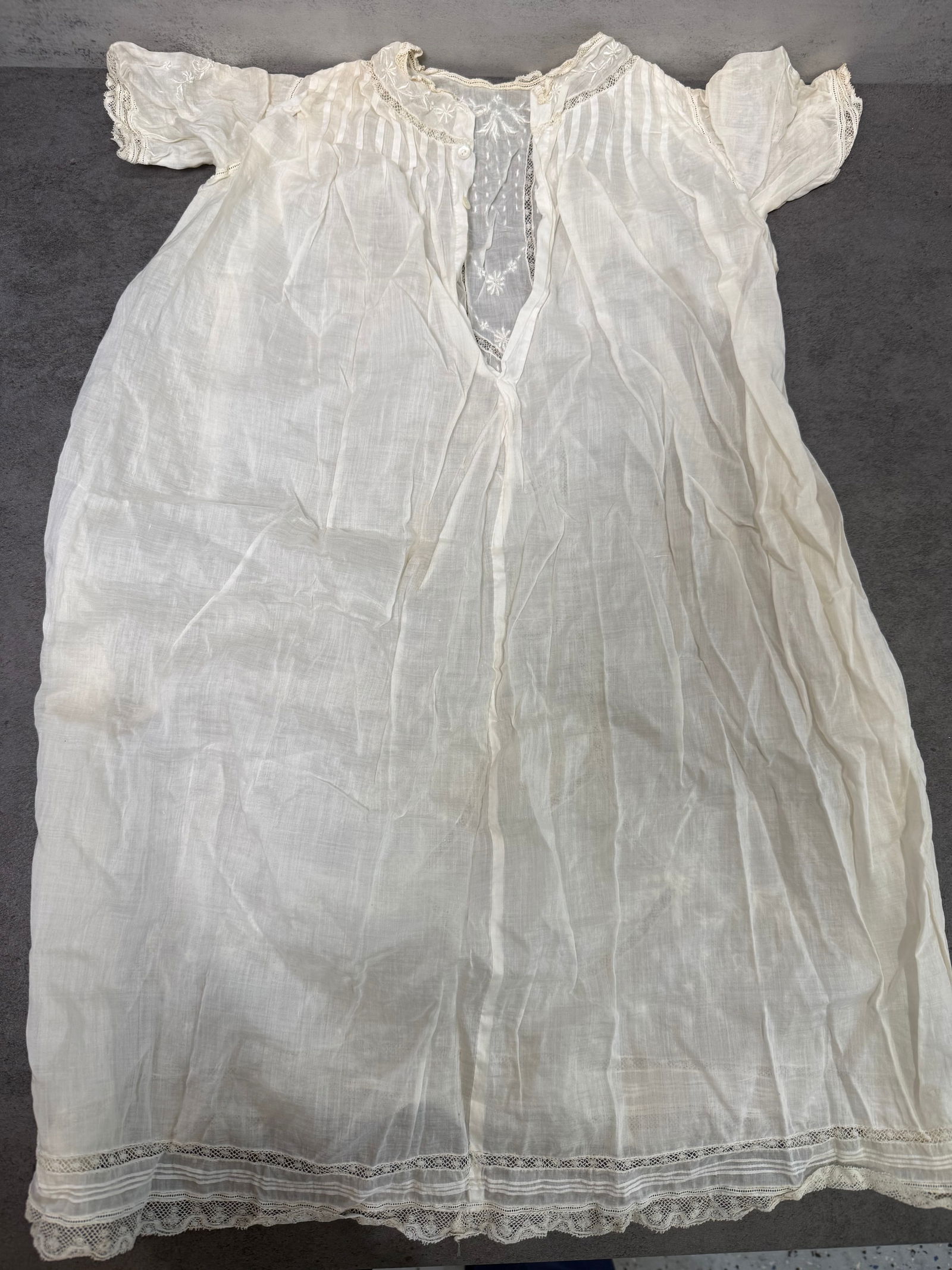 Antique Child White Cotton Lawn Nightgown Lace Trim Embroidered c.1900: Antique child's white cotton lawn nightgown, circa 1890–1910. Features short sleeves with lace cuff trim, embroidered yoke with floral motifs, lace insert at center front placket, pin-tuck pleating