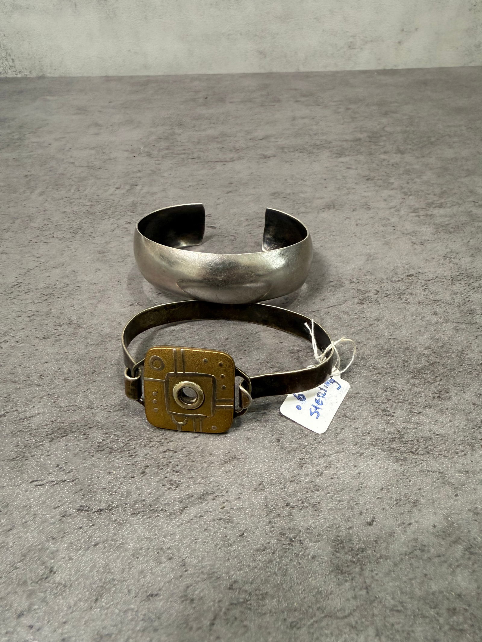 Vintage Sterling Silver Cuff Bracelet and Mixed Metal Modernist Bracelet, Jewelry Set of Two: A distinctive set of two vintage bracelets featuring contrasting design aesthetics.One bracelet is a classic sterling silver cuff with a smooth, polished surface and clean minimalist form, reflecting