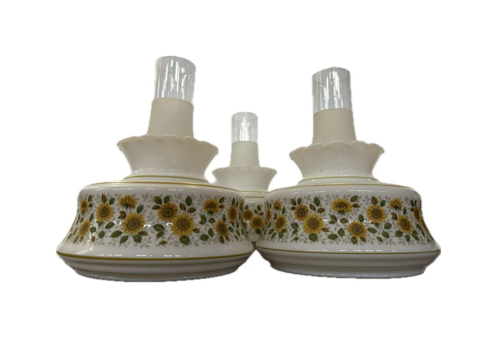 Vintage Milk Glass Floral Oil Lamps with Satin Glass Chimneys, Farmhouse Decor Set of Three: A beautifully coordinated set of three vintage oil-style lamps, featuring softly rounded milk glass bodies adorned with delicate sunflower garlands in warm golden hues.The design evokes a nostalgic