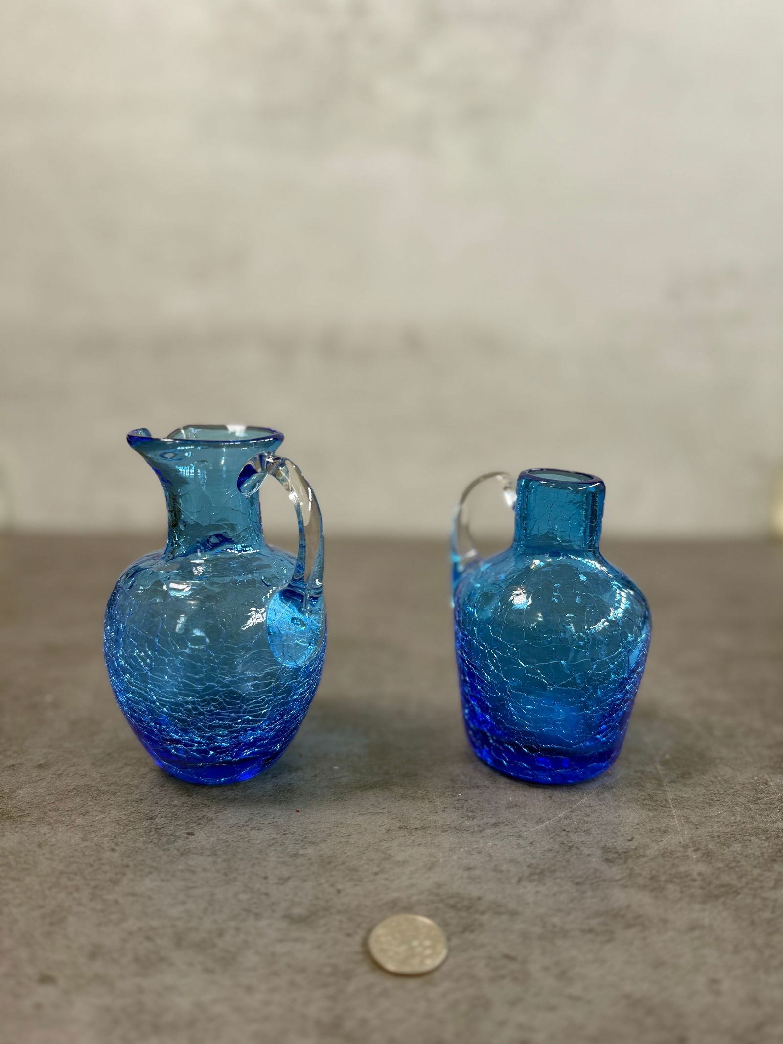 Charming Pair of Vintage Blue Crackle Glass Mini Pitchers, Handled, Decorative Accent: A delightful pair of vintage blue crackle glass mini pitchers, each featuring a rich gradient from deep cobalt to lighter aqua tones. The textured crackle finish catches the light beautifully, while