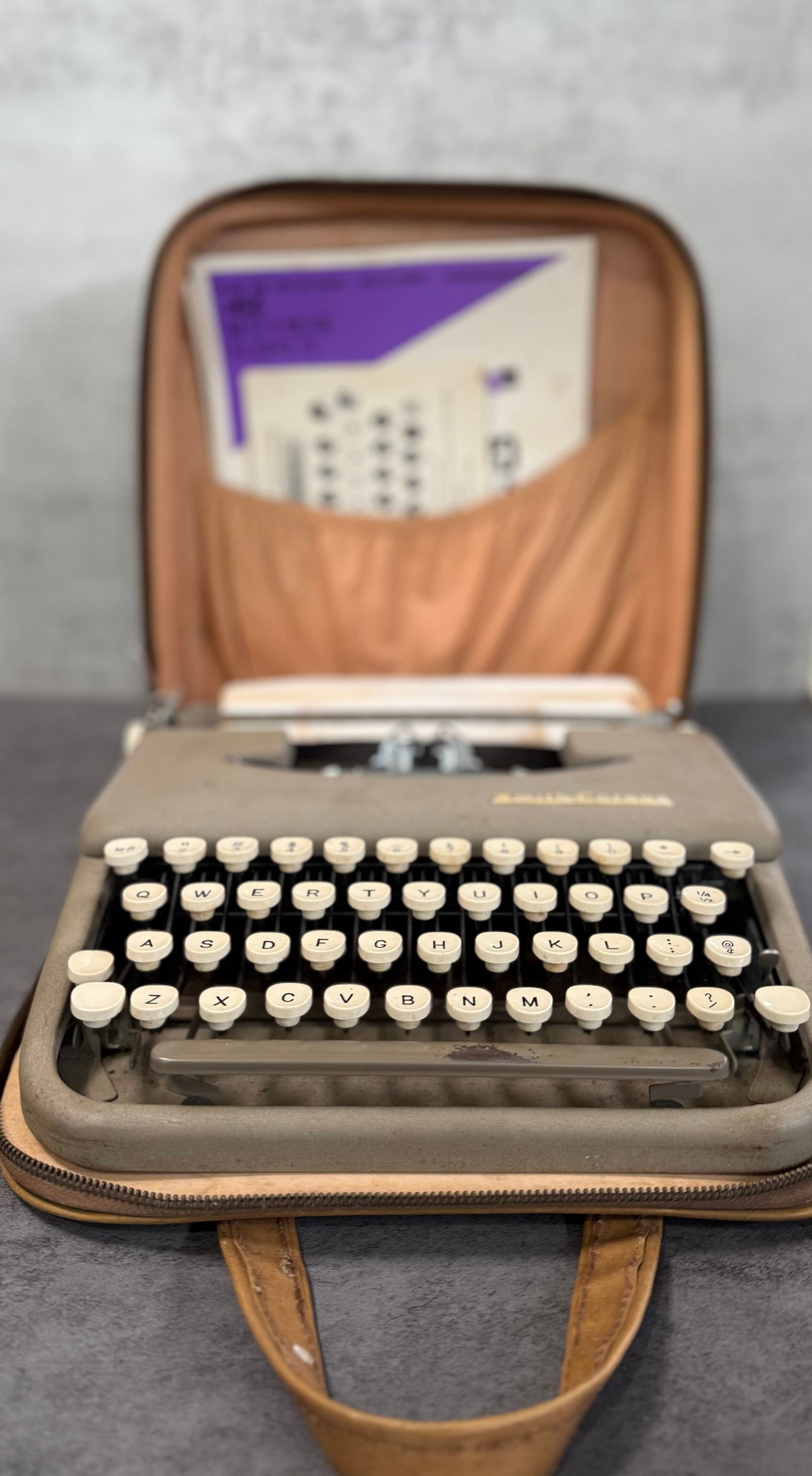Vintage Smith-Corona Portable Typewriter with Case, Mid Century Manual Typewriter: A vintage Smith-Corona portable manual typewriter housed in its original carrying case.This mid-century example features classic round cream-colored keys, a compact design, and durable metal construct