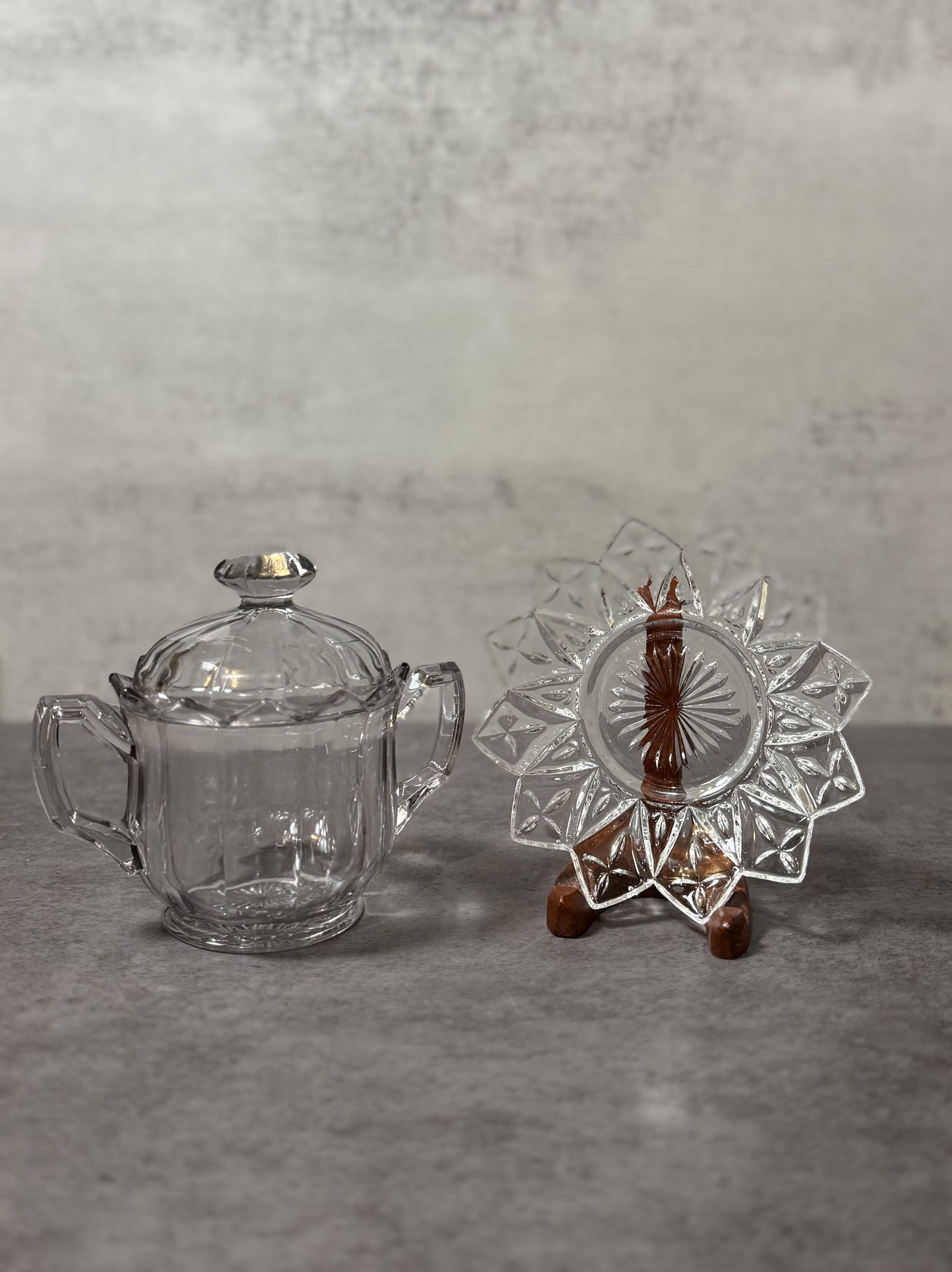 Vintage Pressed Glass Sugar Bowl with Lid & Star Pattern Plate (2 pcs): A mixed lot of vintage pressed glass items, including a lidded sugar bowl and a decorative star pattern plate.The sugar bowl features a classic rounded form with molded panel sides, matching lid, and