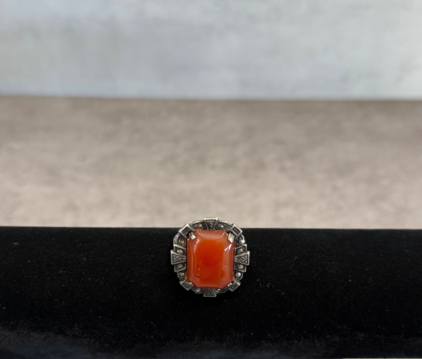 Vintage Sterling Silver Ring with Red Stone – Art Deco Style Statement Jewelry: A striking vintage ring crafted in sterling silver, featuring a vibrant red stone set in a bold geometric design.The setting reflects an Art Deco–inspired aesthetic, with detailed metalwork framing