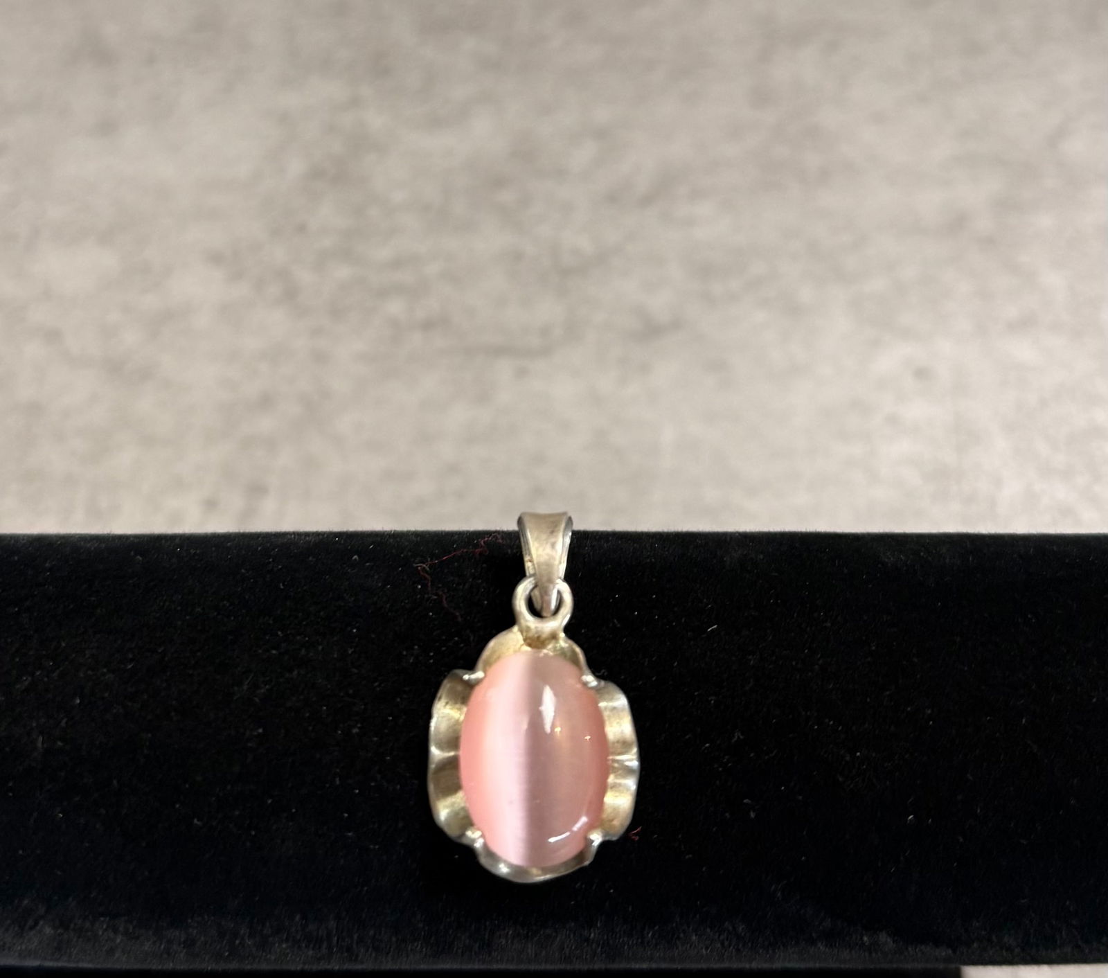 Vintage Silver Pendant with Pink Cat’s Eye Stone – Elegant Cabochon Jewelry: A charming vintage silver pendant featuring a soft pink cabochon stone with a distinctive cat’s eye effect.The stone displays a luminous band across its surface, creating a subtle shifting light