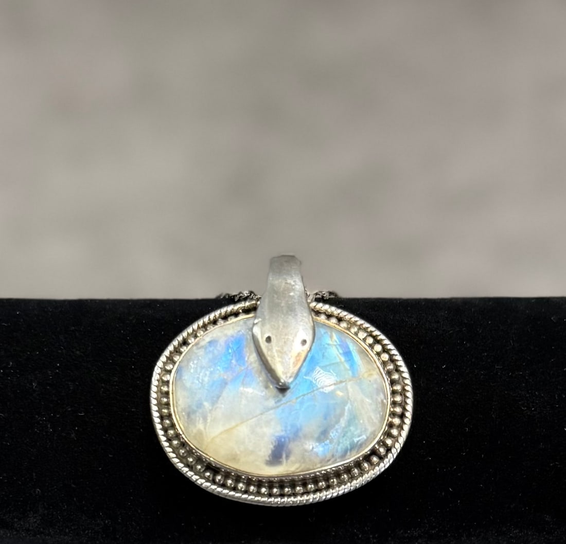 Vintage Sterling Silver Necklace with Moonstone Cabochon Pendant – Iridescent Statement Jewelry: A striking vintage necklace featuring a sterling silver chain and a large cabochon pendant with a moonstone-like iridescent glow.The pendant displays beautiful flashes of blue and soft tonal