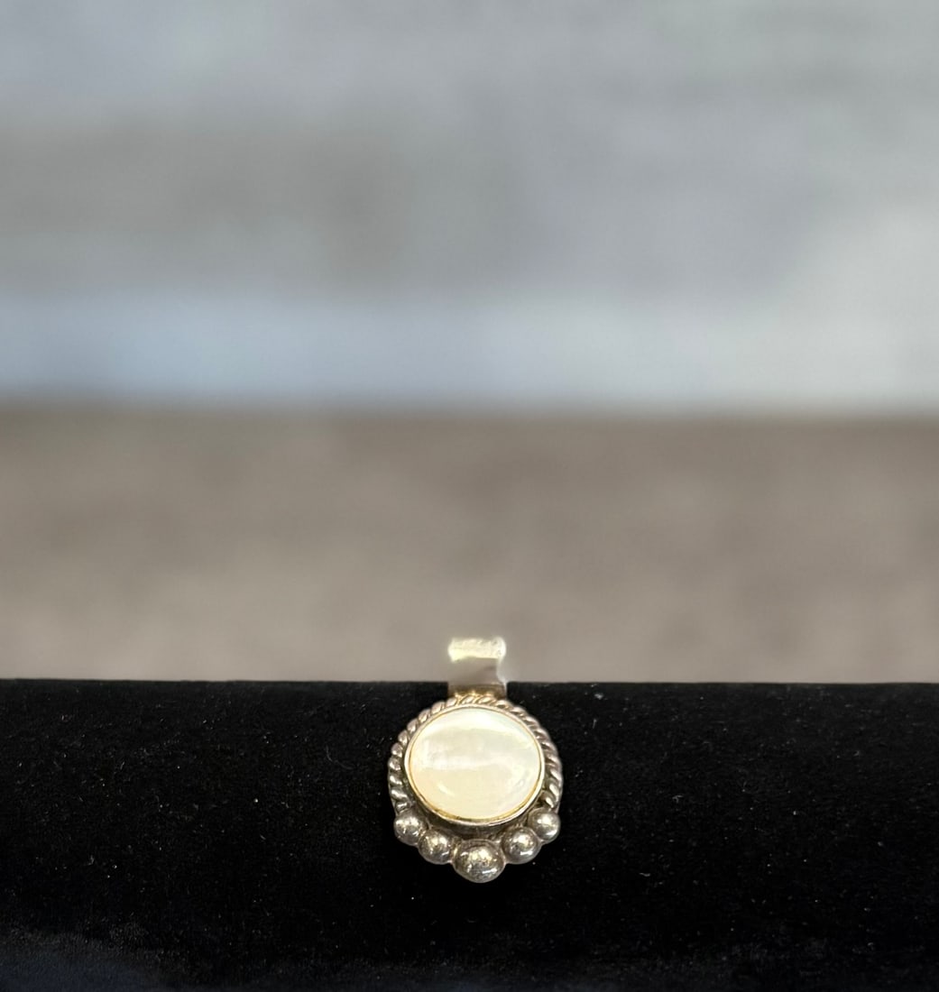 Vintage Sterling Silver Pendant with White Cabochon Stone – Boho Style Jewelry: A charming vintage pendant crafted in silver, featuring a smooth white cabochon stone set in a decorative frame.The design displays a soft, milky tone with subtle translucency, giving the piece a