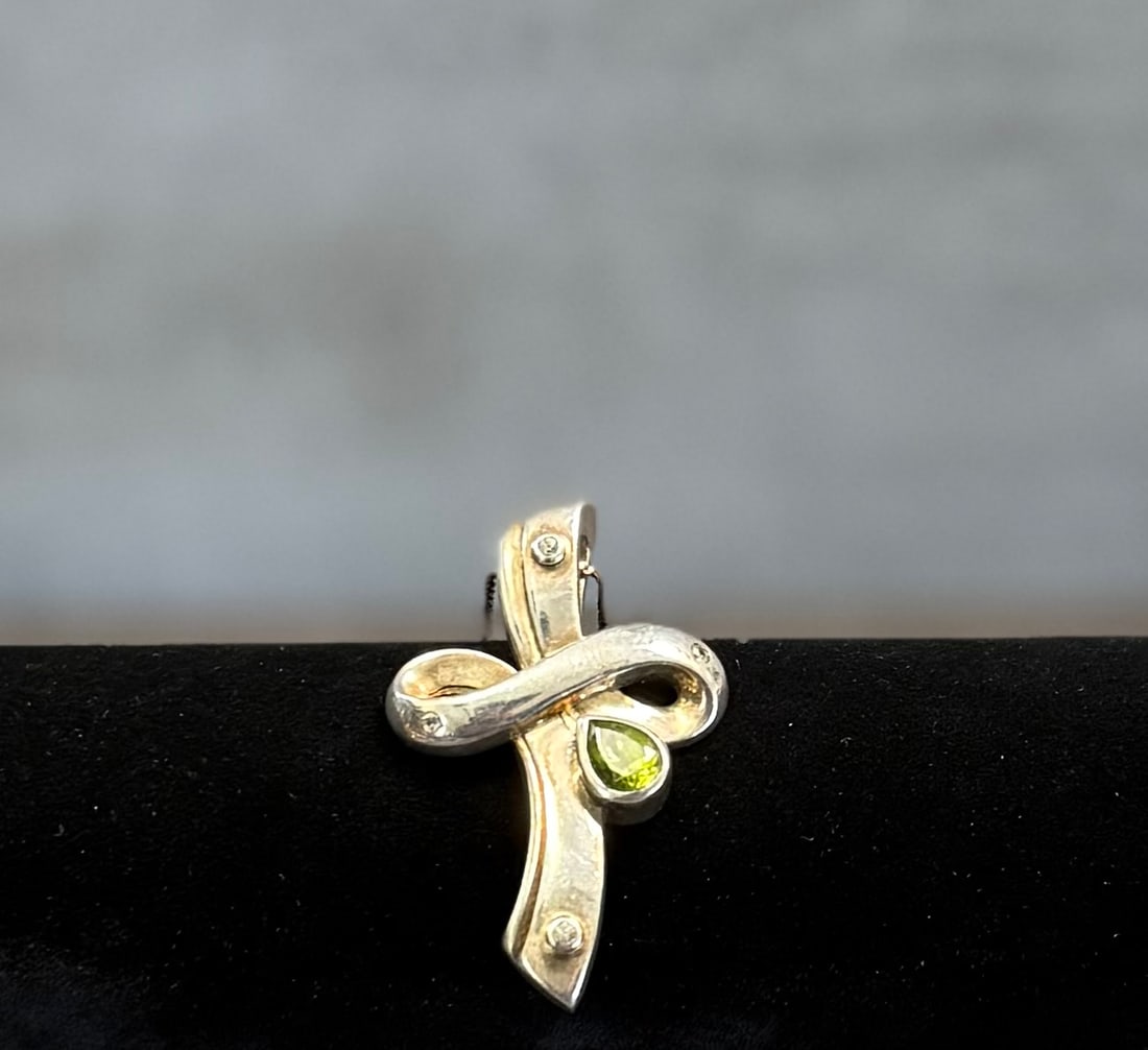 Vintage Sterling Silver Necklace with Abstract Cross Pendant & Green Stone – Modern Designer Style: A distinctive vintage necklace crafted in sterling silver, featuring an abstract cross-shaped pendant accented with a vibrant green stone.The sculptural design combines flowing, organic lines with a