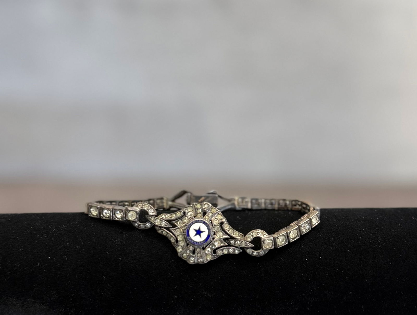 Vintage Sterling Silver American Legion Auxiliary Bracelet – Marcasite Style Rhinestone Jewelry: A striking vintage sterling silver bracelet featuring an ornate design with marcasite-style detailing and sparkling rhinestone accents.The centerpiece displays the emblem of the American Legion