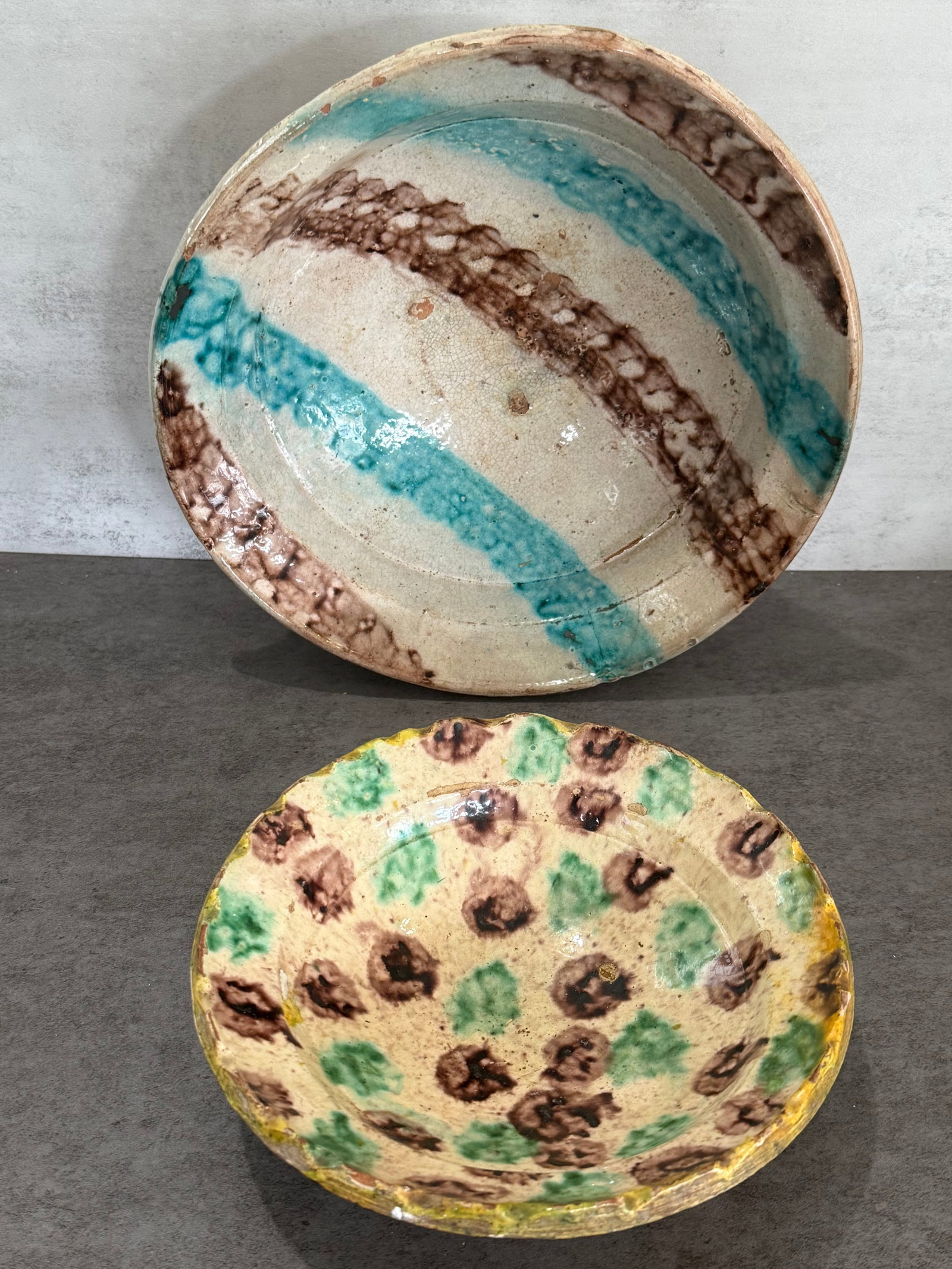 Pair of Antique Hand Painted Glazed Earthenware Bowls: Collection of two antique handmade earthenware pottery bowls featuring rustic hand-painted glaze decoration. One example decorated with flowing turquoise and manganese style banding, the other with