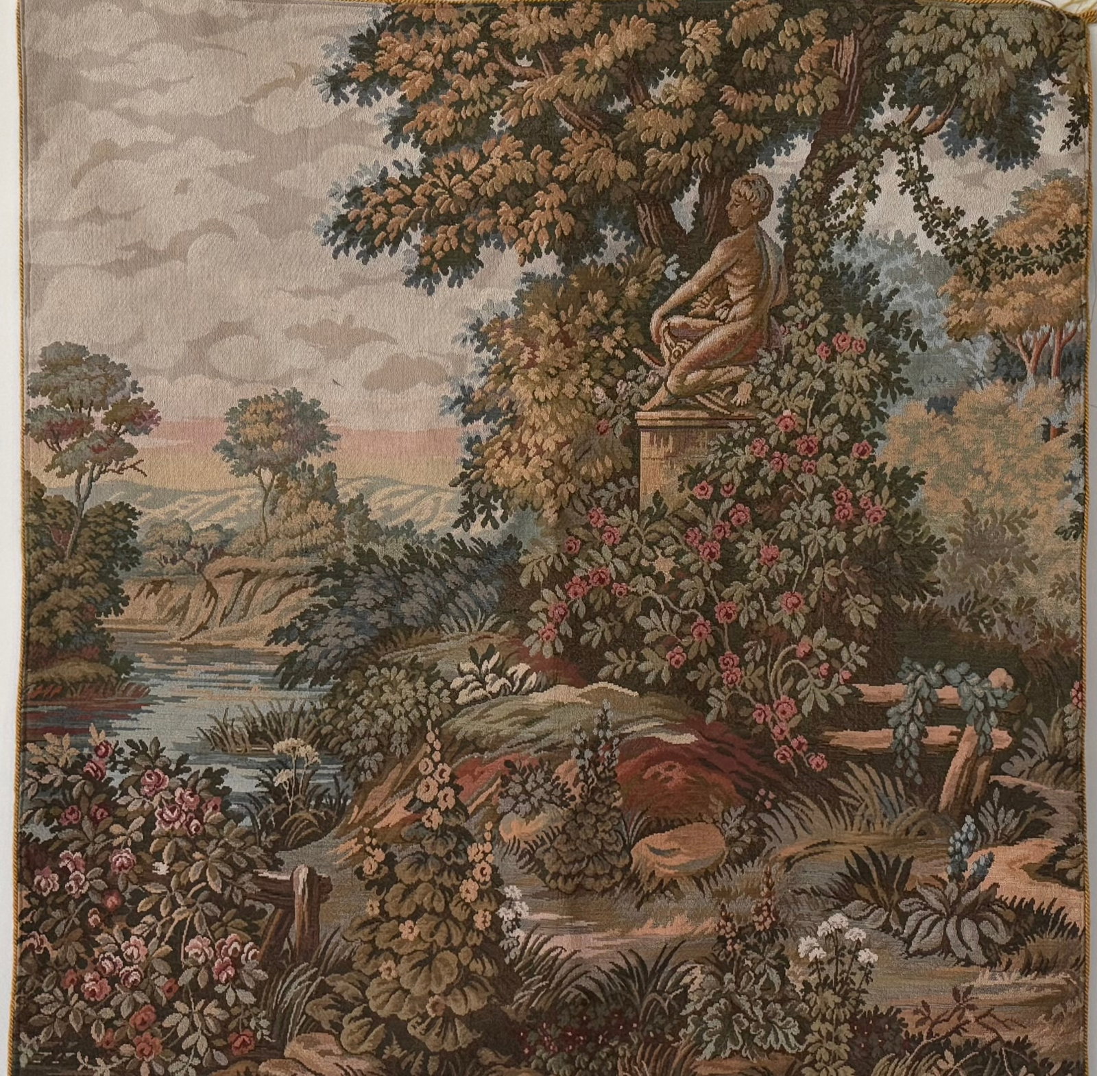 European Style Garden Scene Tapestry Wall Hanging: Featuring a romantic pastoral landscape with flowering foliage, a classical garden statue, and river scenery rendered in rich woven detail. Likely mid-to-late 20th century decorative tapestry in the E