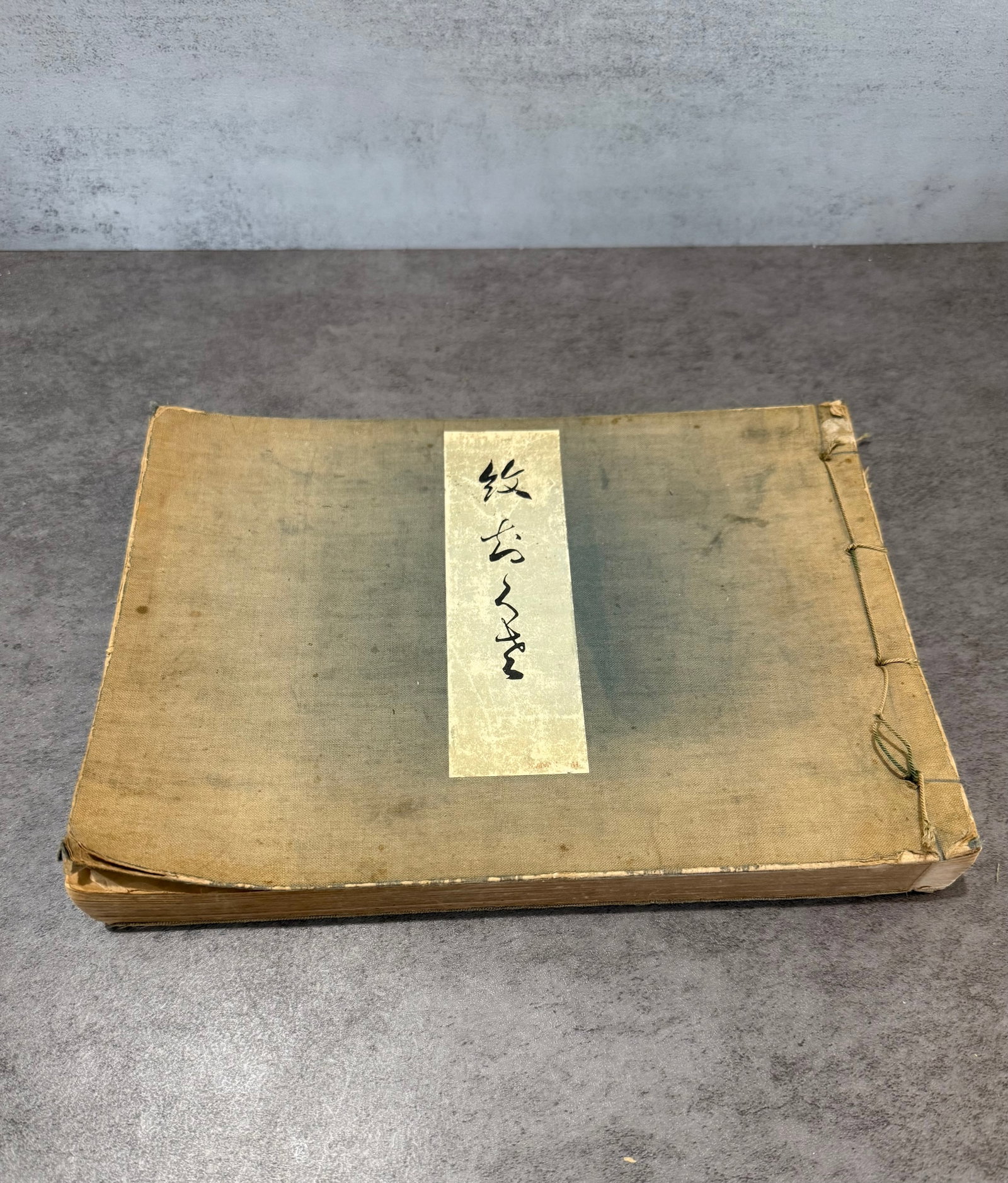 Japanese Kamon Monsho Pattern Woodblock Reference Book: A Japanese reference book featuring traditional kamon (family crest) and monsho designs rendered in striking black-and-white graphic form. The volume contains numerous stylized crest motifs, floral