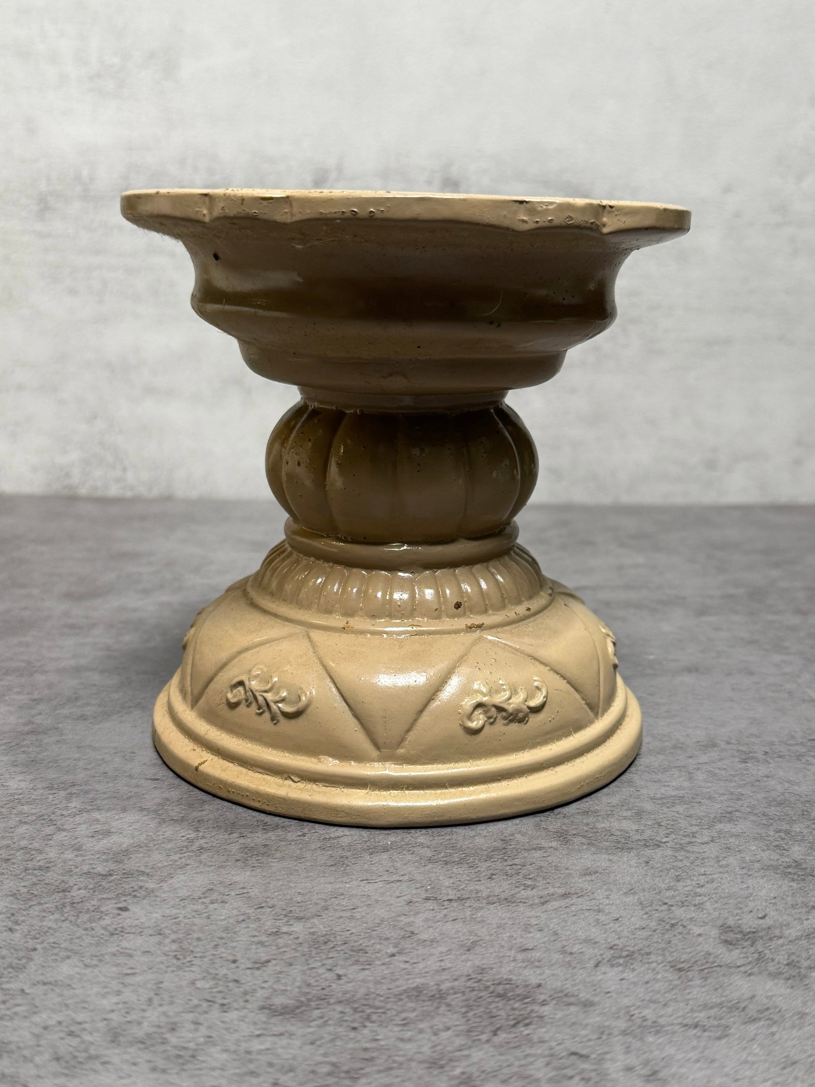 Vintage Distressed Metal Pedestal Candle Holder Farmhouse Decor: Vintage metal pedestal candle holder featuring a distressed cream and brown painted finish with molded classical ornamentation throughout. The elevated form is accented with embossed foliate and