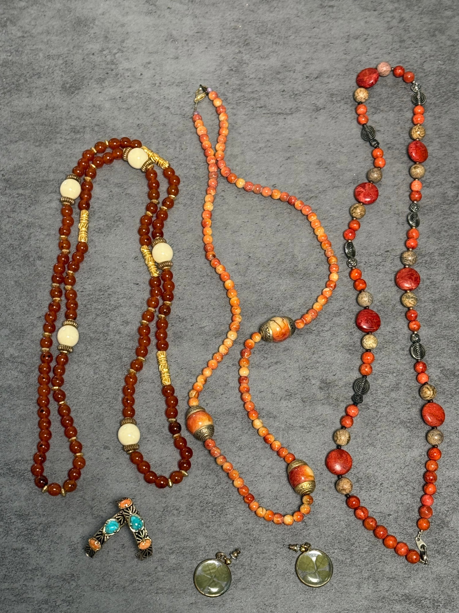 GROUP OF BEADED COSTUME JEWELRY NECKLACES & EARRINGS: A group of assorted beaded costume jewelry pieces, including several necklaces composed of orange, coral-tone, and mottled beads with metal spacers and decorative accents, together with a pair of