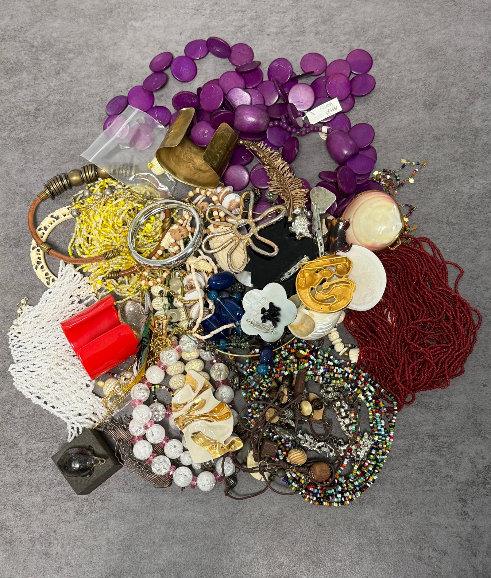 LARGE GROUP OF ASSORTED COSTUME JEWELRY & BEADED ACCESSORIES: A large assorted group of costume jewelry and decorative accessories, including necklaces, bracelets, earrings, cuffs, shell ornaments, beaded strands, carved pendants, colorful glass and plastic