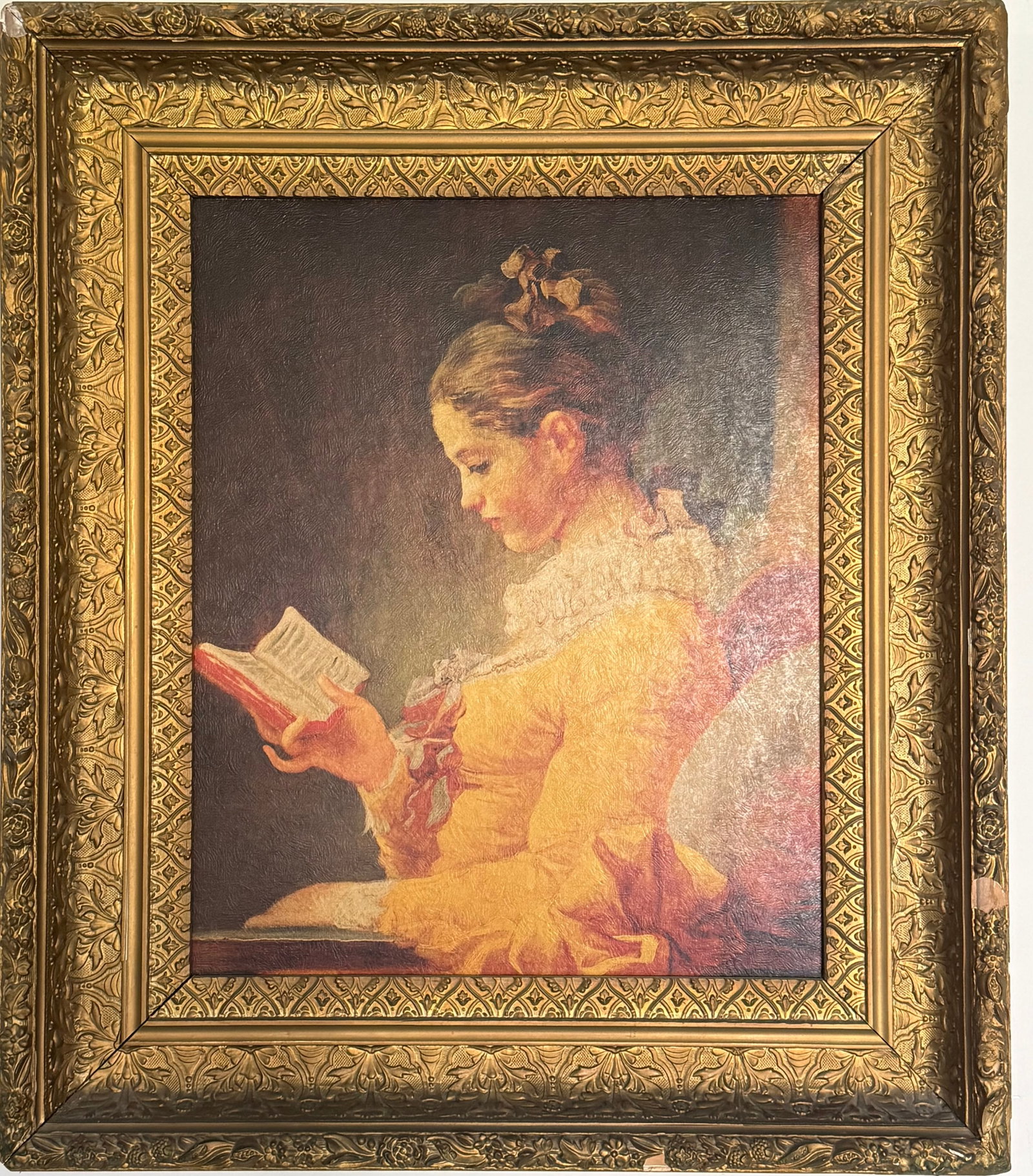 FRAMED OIL PRINT AFTER JEAN-HONORÉ FRAGONARD “YOUNG GIRL READING”: A framed oil print reproduction of “Young Girl Reading” after the celebrated French Rococo artist Jean-Honoré Fragonard. The composition depicts a young woman absorbed in reading, rendered