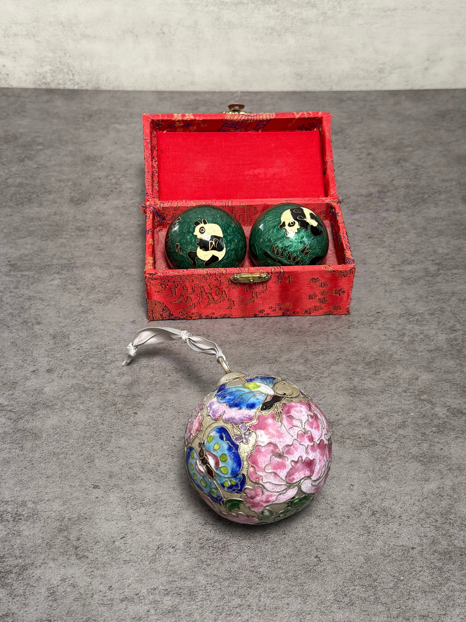CHINESE CLOISONNÉ ENAMEL PUZZLE BALLS & CHRISTMAS ORNAMENT: Group including a pair of Chinese cloisonné enamel hand exercise balls decorated with panda motifs, housed in a fitted fabric presentation box, together with a cloisonné enamel hanging ornament