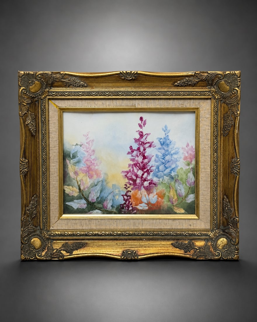SIGNED HAND-PAINTED FLORAL PORCELAIN PLAQUE IN GILT FRAME: A signed hand-painted porcelain plaque depicting a colorful floral composition with tall blossoms in shades of pink, blue, burgundy and orange against a softly rendered background. Signed within the i