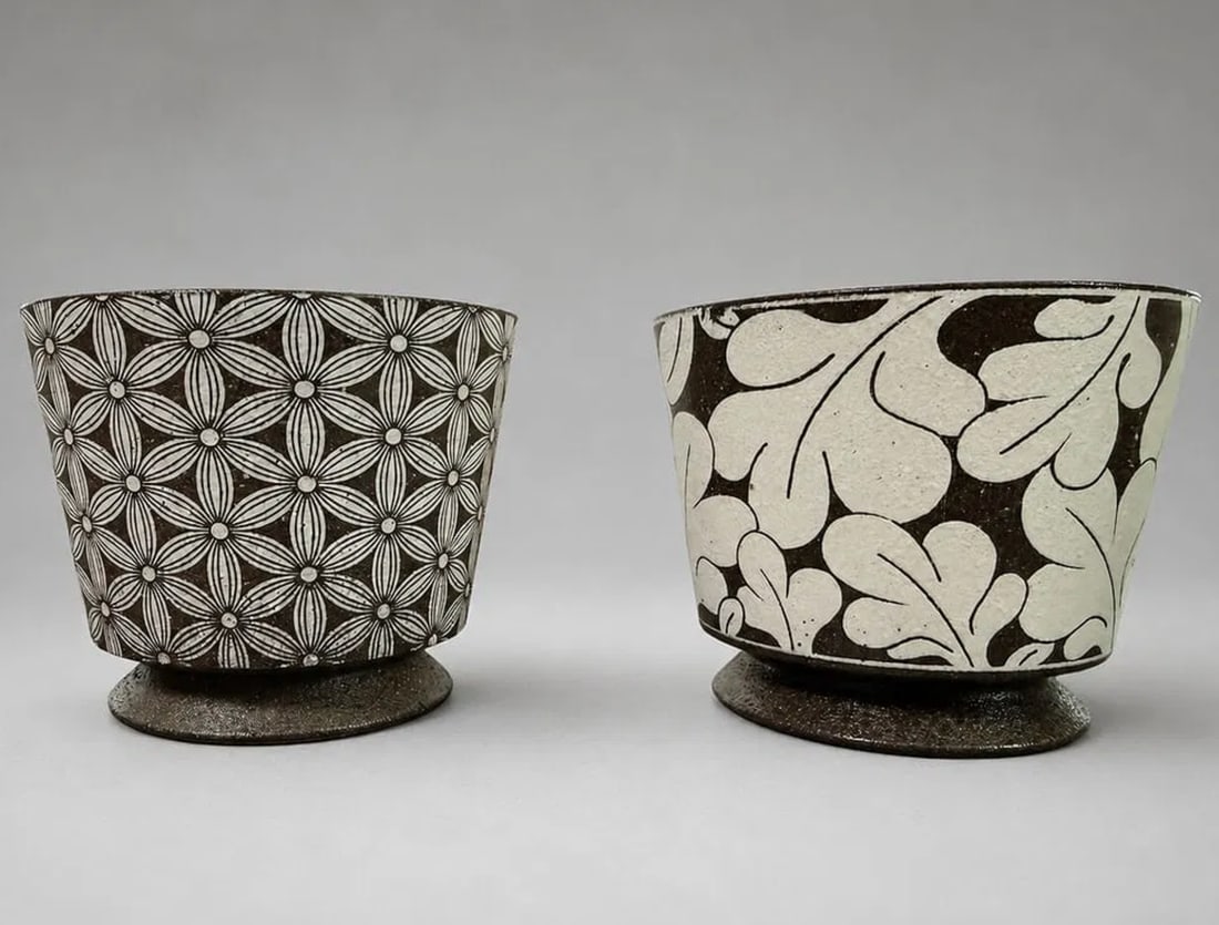 Pair of Asian Style Ceramic Coffee Cups, 3 Inches: A pair of Asian style ceramic coffee cups measuring approximately 3 inches in height. Each cup features a distinctive hand-decorated monochromatic pattern, one with an intricate geometric floral motif