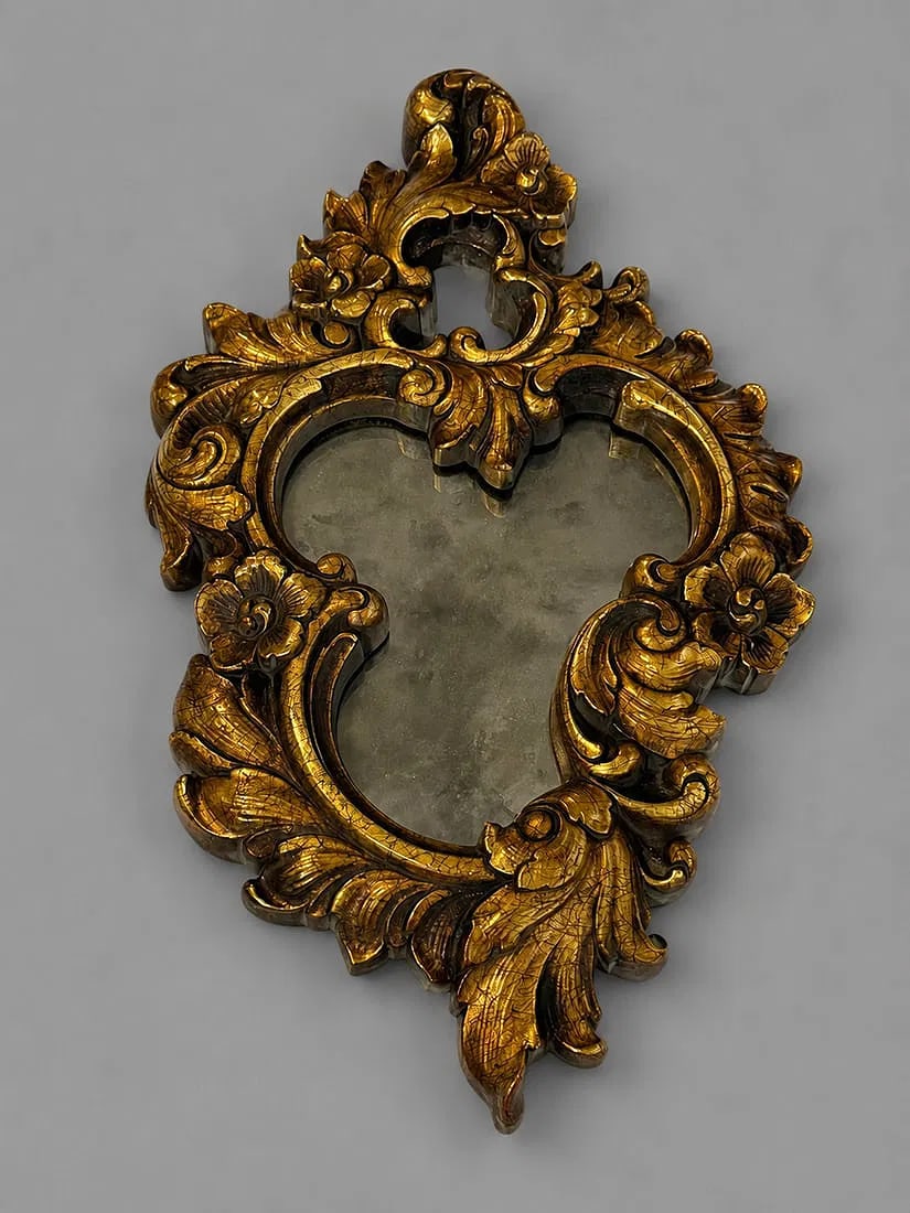 Vintage Rococo Style Gilt Wall Mirror: A decorative vintage Rococo-style wall mirror featuring an elaborate gilt frame with deeply carved scrolling acanthus leaves, floral motifs, and pierced cresting. The asymmetrical silhouette and richl