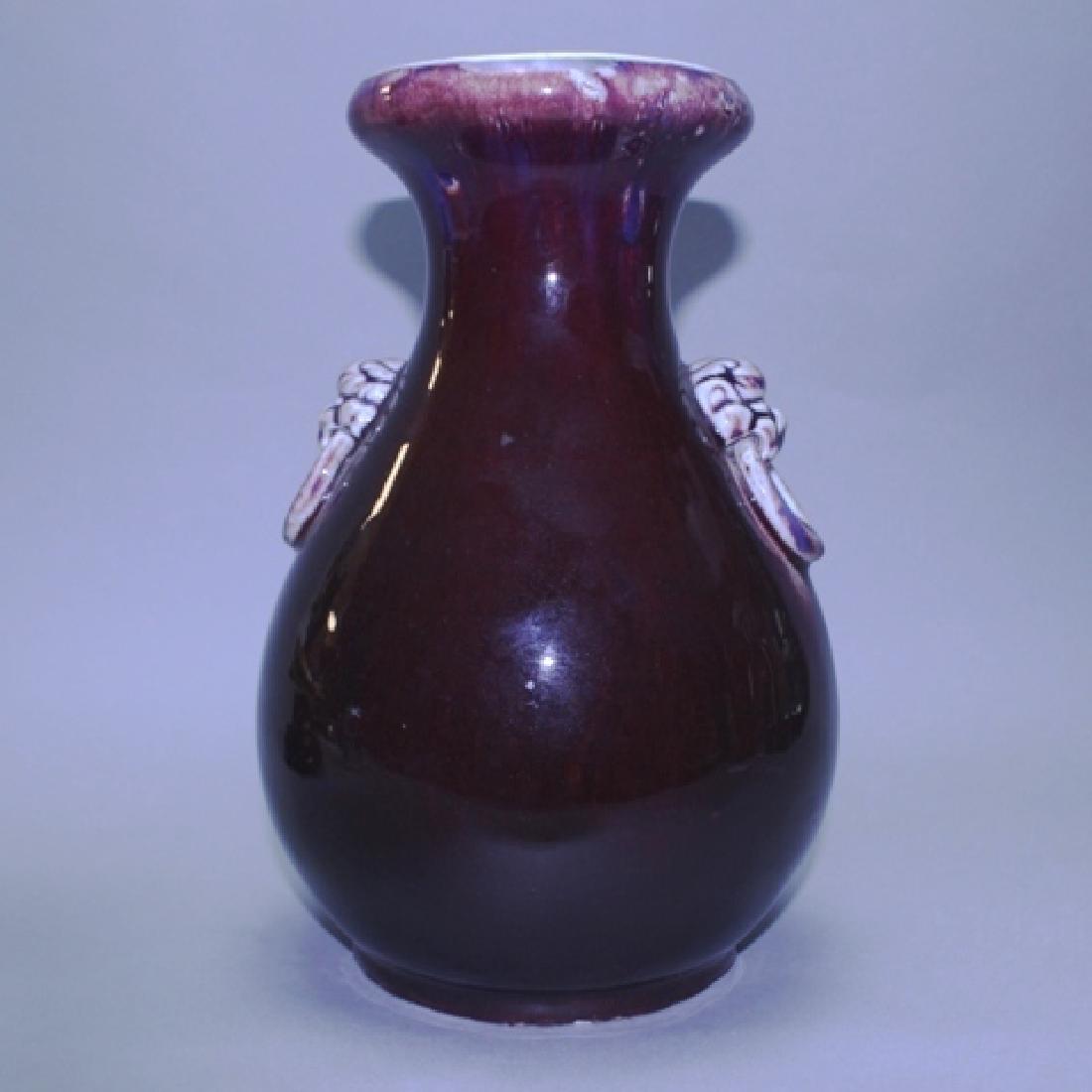 Chinese Sang de Boeuf Vase with Foo Dog Handles: Chinese ceramic vase with Sand de Boeuf glaze, foo dog applied faux handles. H. 10.5" D. 7". Good condition, some wear on bottom, small chip in glaze around the neck.