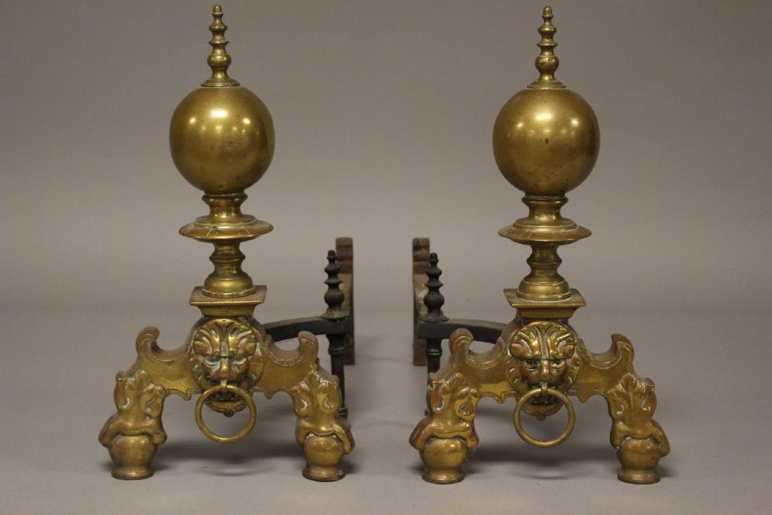Pair of Early Brass Andirons with Gargoyle Faces: Pair of Brass andirons with gargoyle faces on base. Approx. 19" tall. In good age appropriate condition, see photos.