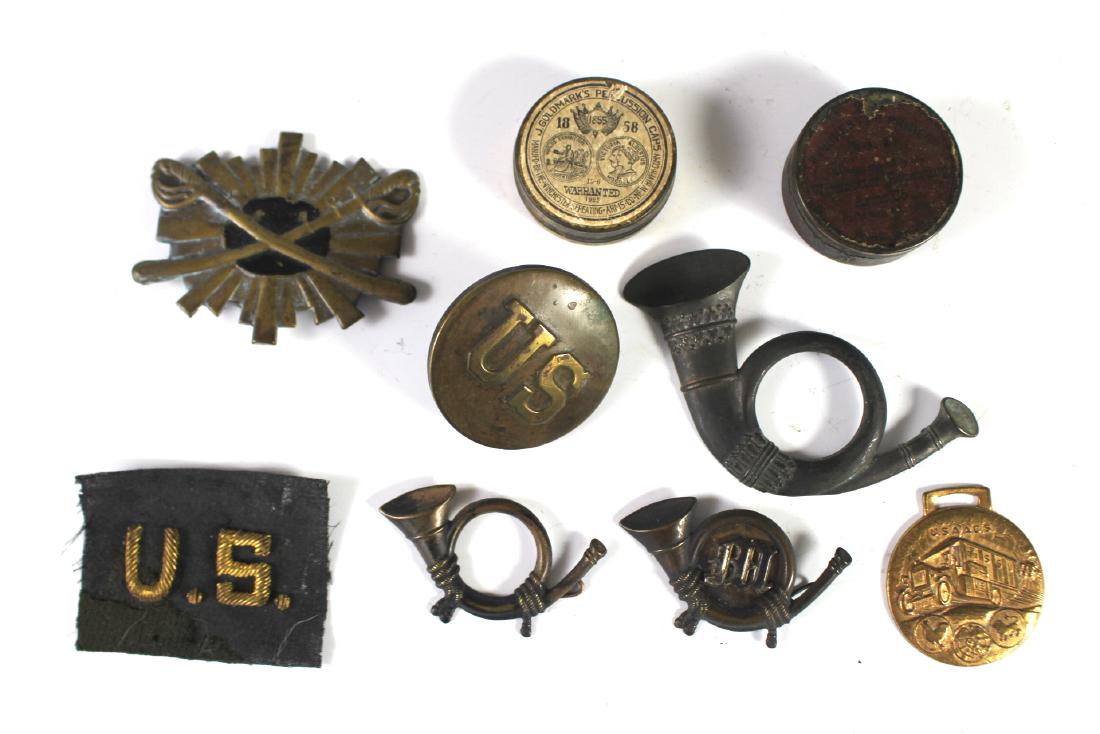 Group of Civil War Insignias, Patches And Percussion: Includes three Civil War brass insignia horns, large US button, U.S. patch. Brass crossed swords insignia, W.W. I Army Ambulance Corp. badge and two percussion caps full tins. All in very good age app