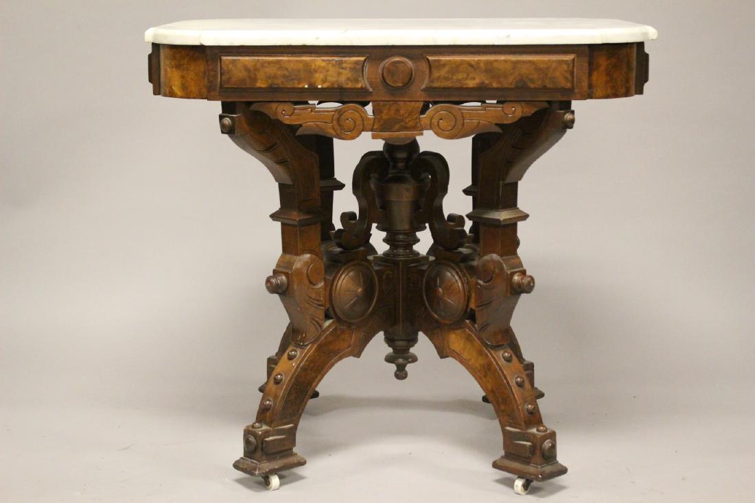 Victorian Renaissance Marble Top Lamp Table: In the manner of Mitchell and Rammelsberg Victorian Renaissance Marble Top Lamp Table. White marble top and carved walnut base as shown. Measuring approx. 29" h x 32" w x 23" d. Condition is consisten