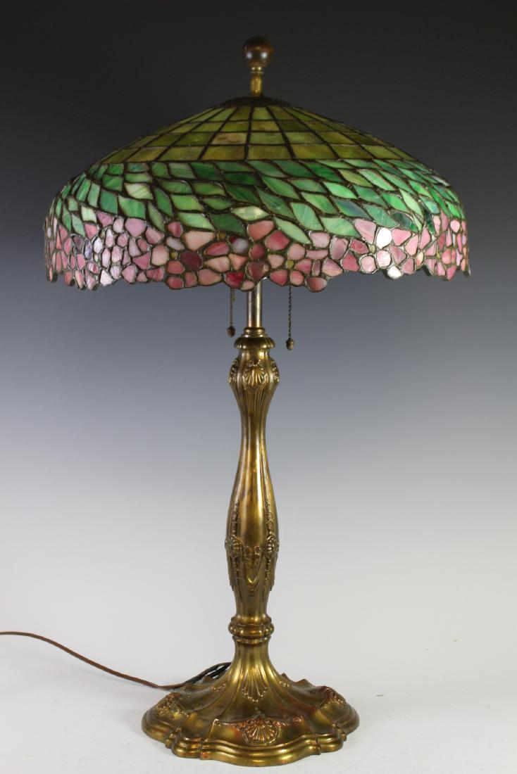 Unique Art Glass Co. "Apple blossom" Lamp: Leaded glass lamp with apple leaves and blossom around base. Unsigned Unique Art Glass Co. The non-metal bronze/copper base is Wilkenson #537 in sea shell and leaf design. Having Hubbard sockets with 