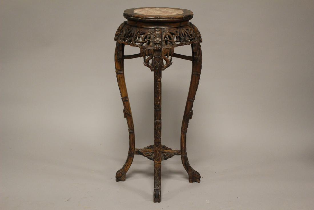 19th Century Chinese Rosewood Stand: Heavily carved with bamboo, foo dogs, hoof feet, scalloped edge and inset pink marble. Stand measuring approx.. 36" H x 14" D Condition is consistent with age having light dust soil and some loose joi