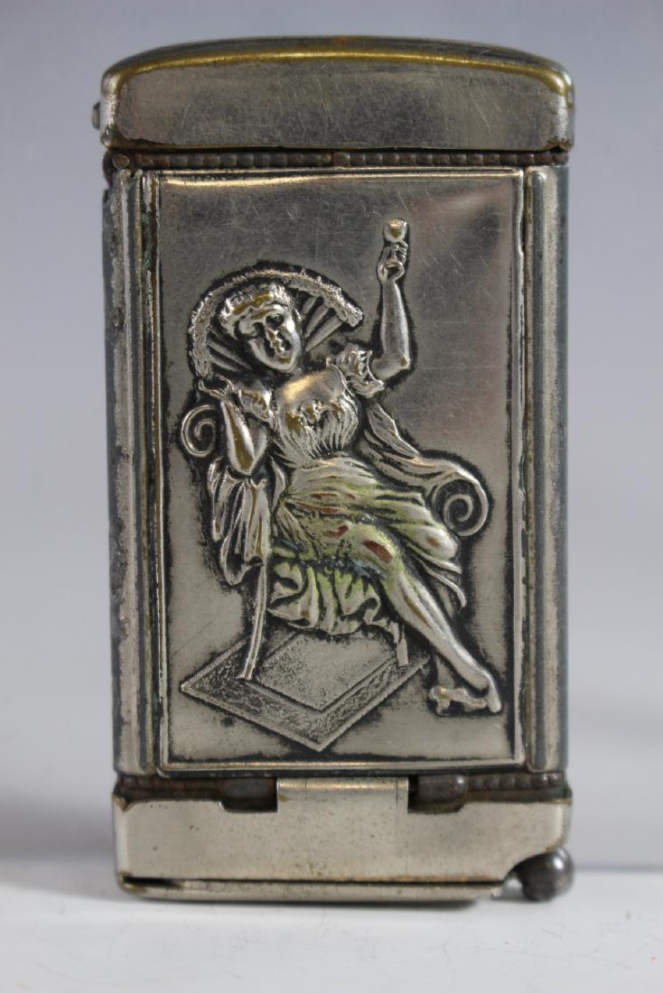 Match Safe with Cigar Cutter: Nickel plated match safe with cigar cutter on base. Repousse figural on both sides as shown. Normal use and wear. Approx 2.75" tall. See photos.