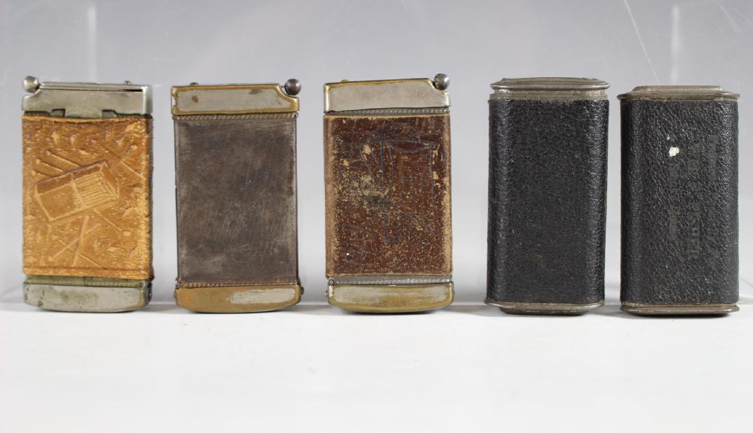 Group of Five Vintage Match Safes: Three leather wrapped match safes with cigar cutter bases as shown and two leather wrapped with advertisement losses as shown. See photos for condition as shown.