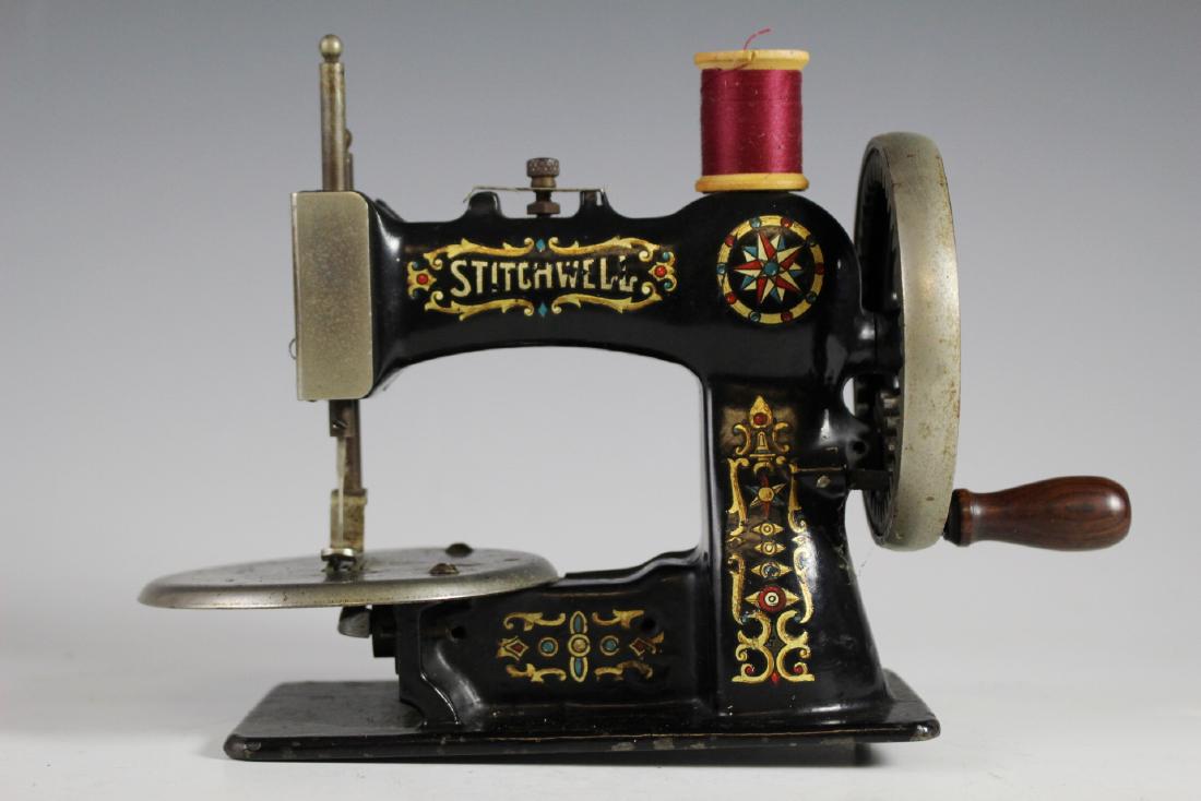 Stitchwell Antique Childs Sewing Machine: Stitchwell cast iron antique child's sewing machine. Having original black finish and stenciling. Approx. 6"t by 9"w. Overall good working age appropriate condition with some paint loss consistent wit
