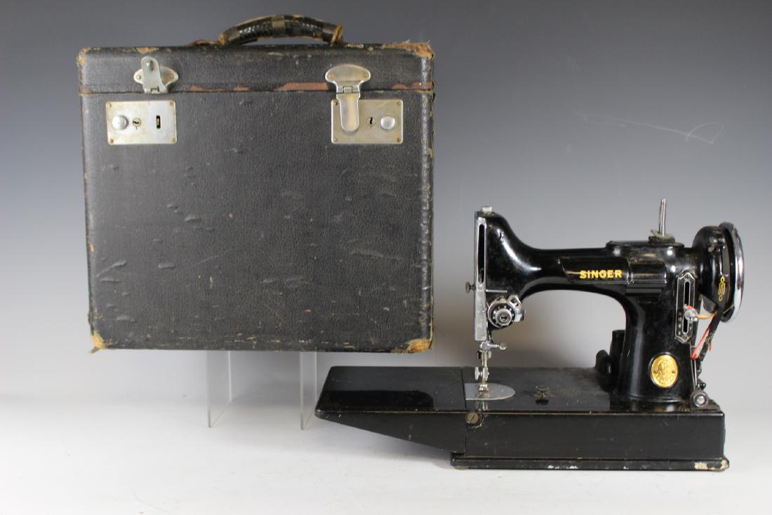 Singer 221 Featherweight Sewing Machine: Singer featherweight electric sewing machine with original carry case, foot pedal and used condition. Some dust soil and signs of light use. Faint musty basement odor to case (no real bad, but there).