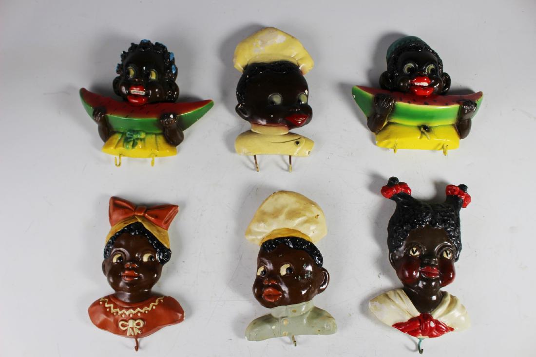 Black Americana Pot Hook Holders: Collection of eight (8) black Americana related hook holders. Youth eating watermelon as shown, see photos. Composition or chalk painted. Scratches and paint deficient areas are present.